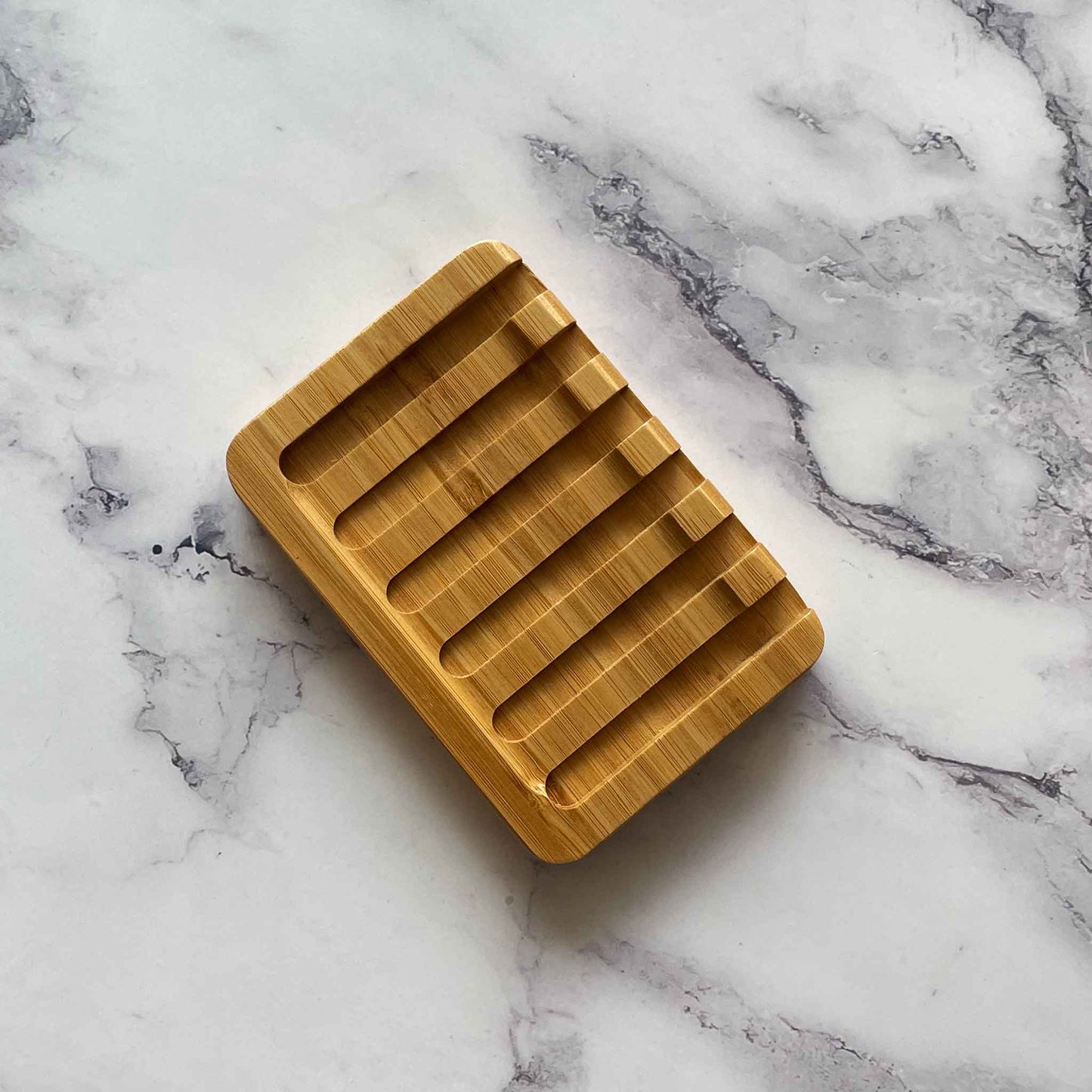 Bamboo soap dish on a marble surface