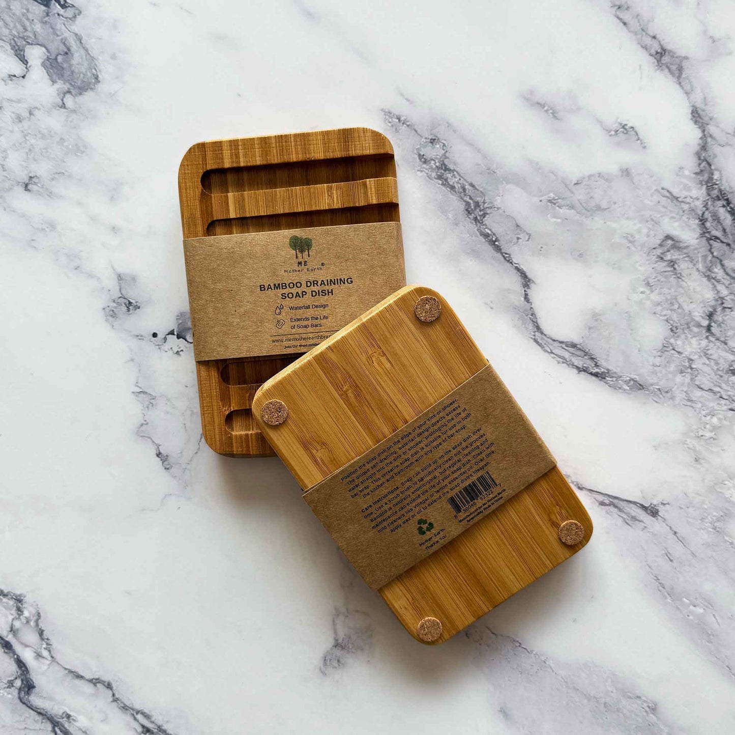 Two bamboo draining soap dishes, front and back, on a marble surface with labels.