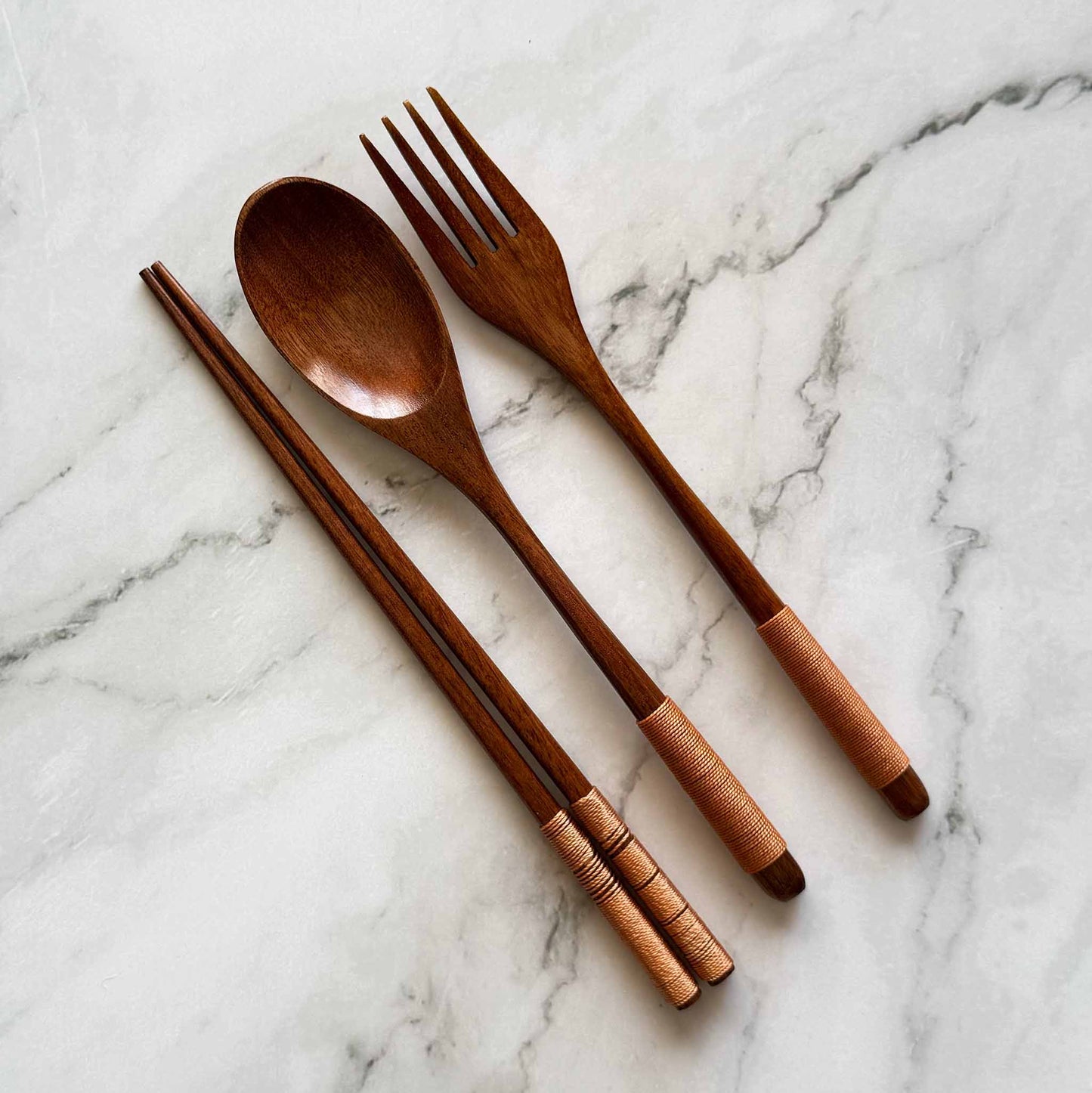 Coconut spoon, fork, and chopsticks on a marble surface