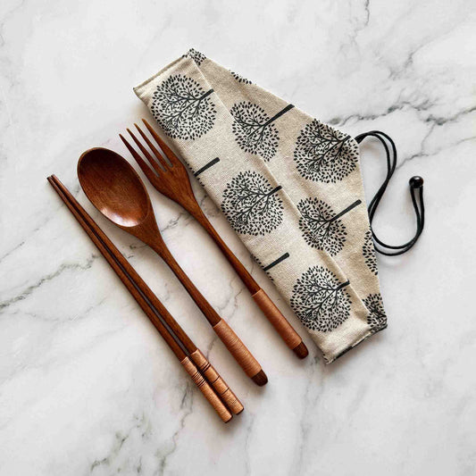 Coconut cutlery set including chop sticks, spoon, fork, cotton pouch on a marble surface