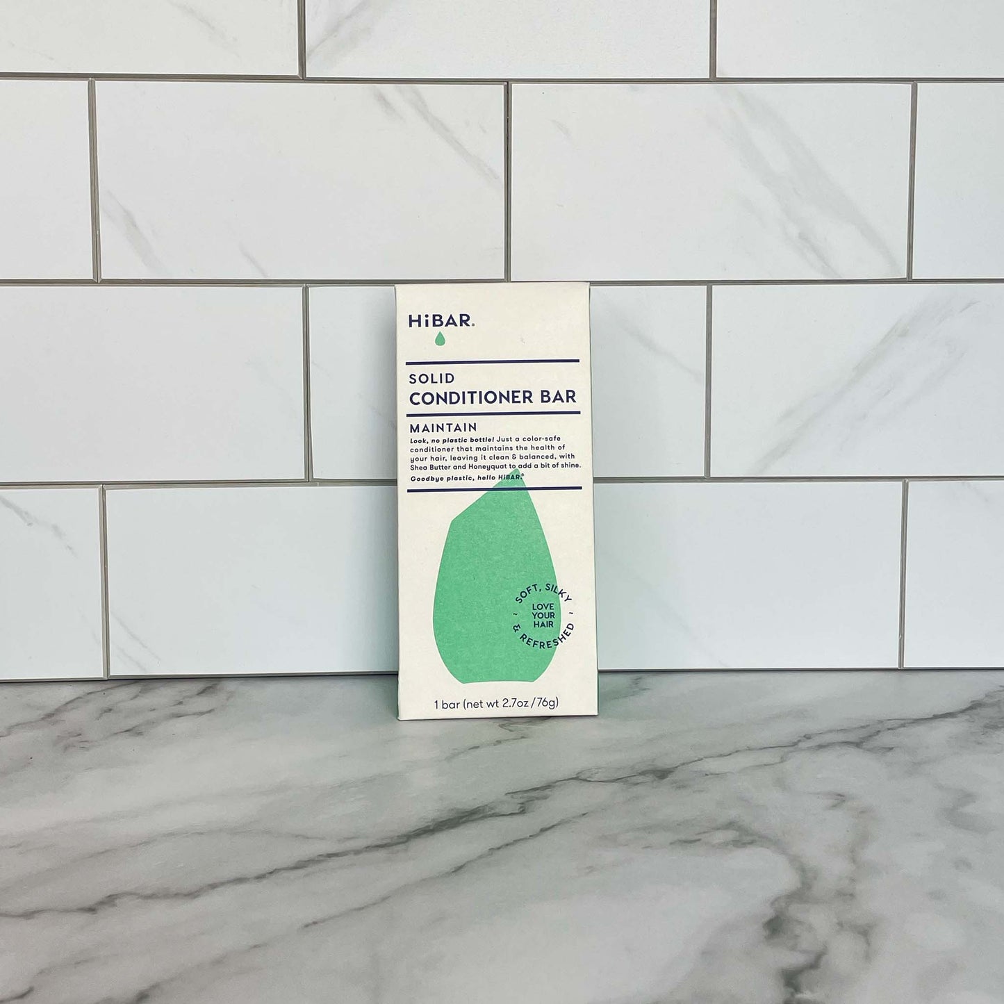 HiBAR Maintain solid conditioner bar packaging on a tiled bathroom wall