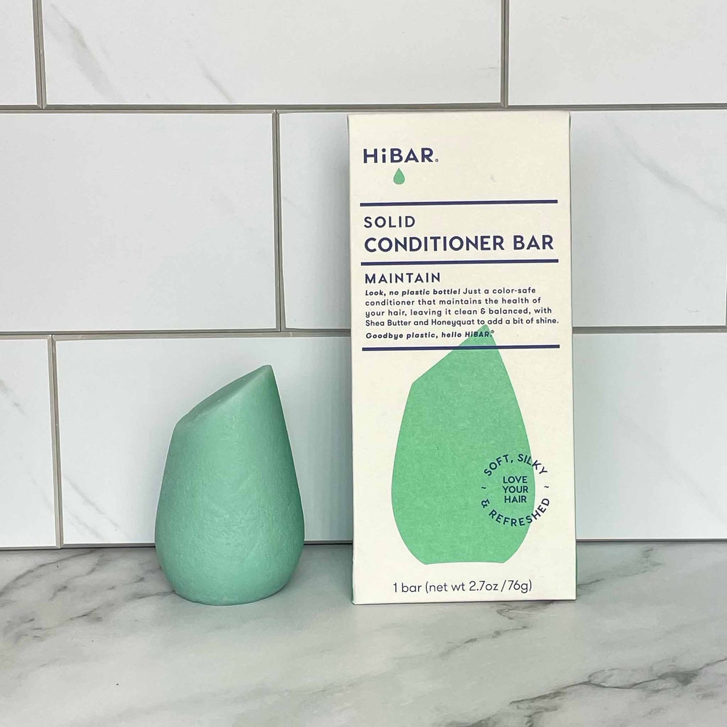 HiBAR Maintain solid conditioner bar and its packaging on a marble surface with tiled wall background