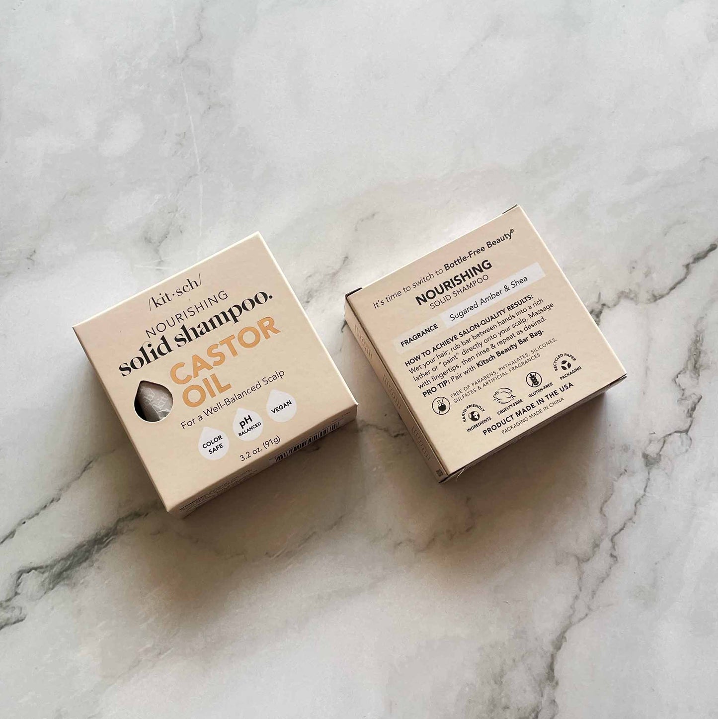 Two cardboard boxes of Kitsch nourishing solid shampoo on a marble surface