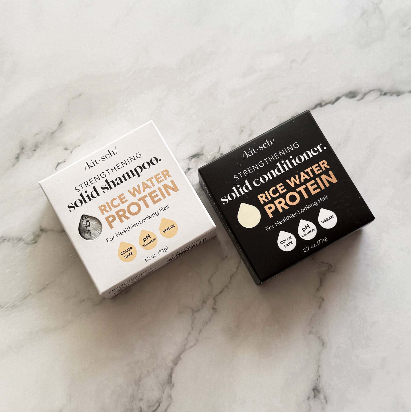 Two boxes of Kitsch rice water protein shampoo and conditioner on a marble surface