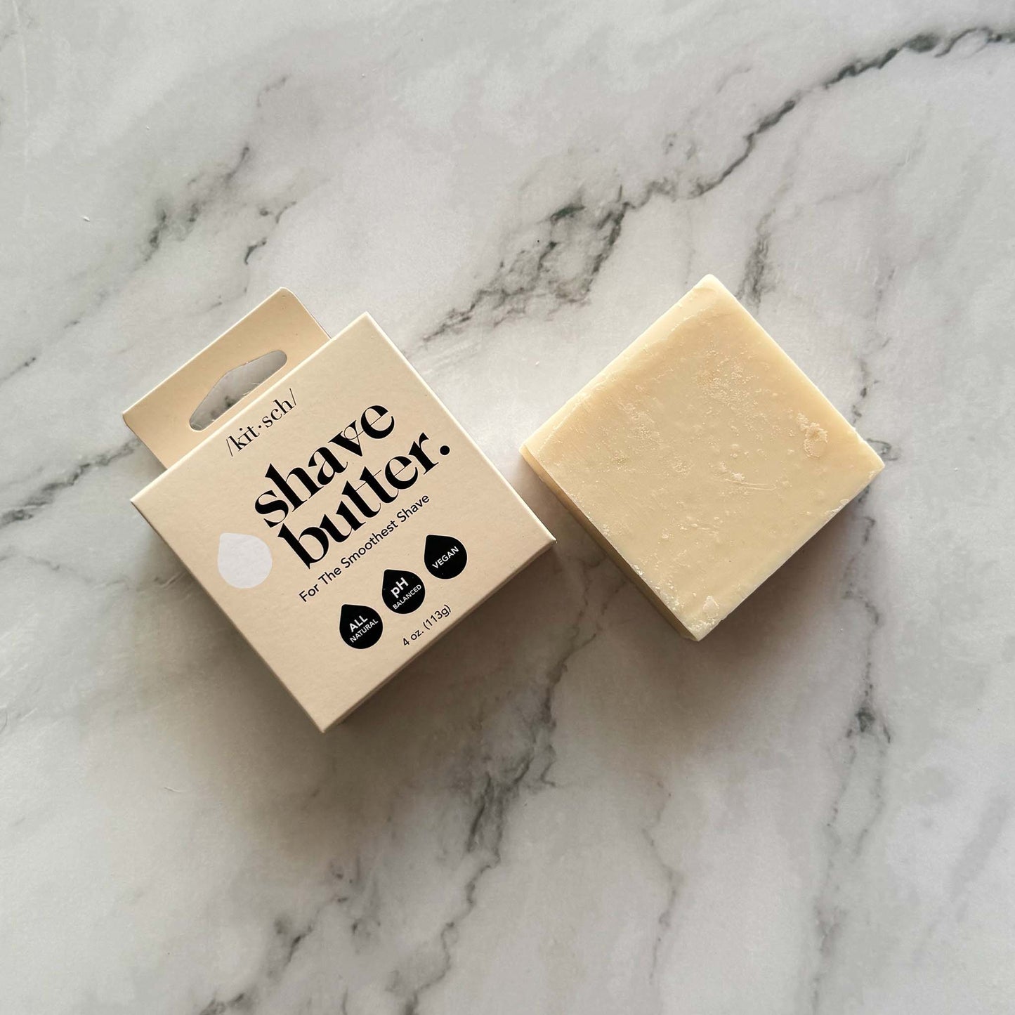 Kitsch Shave butter bar packaging and a bar on a marble surface