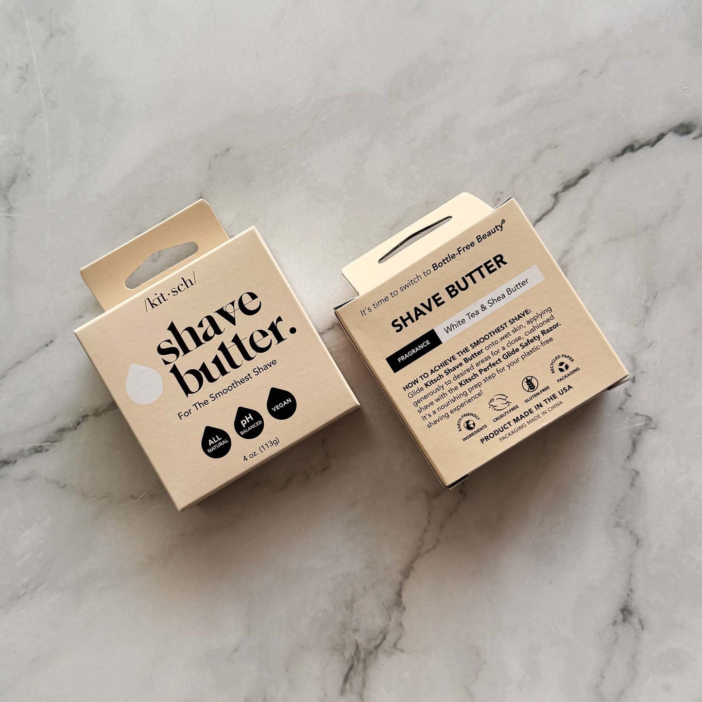 Two cardboard boxes of Kitsch shave butter bars on a marble surface