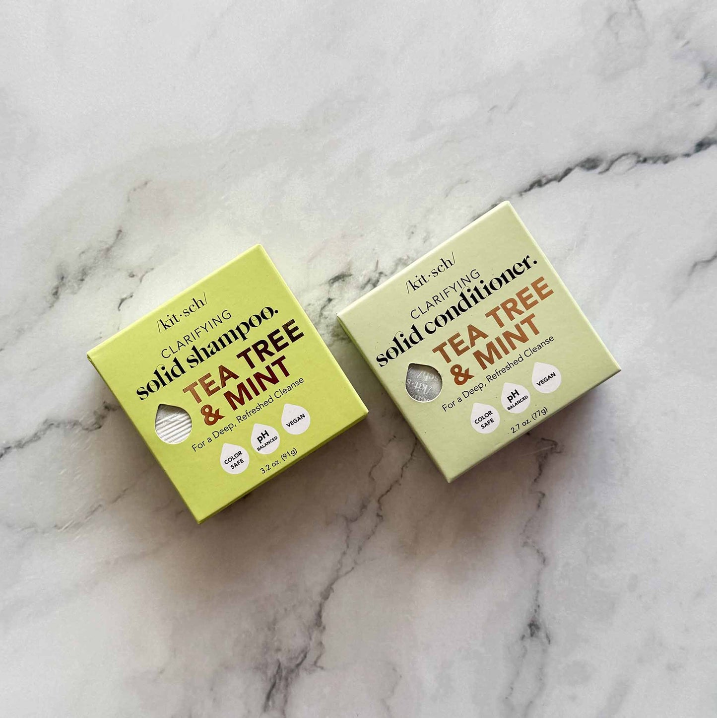 Two boxes of Kitsch solid shampoo and conditioner on a marble surface