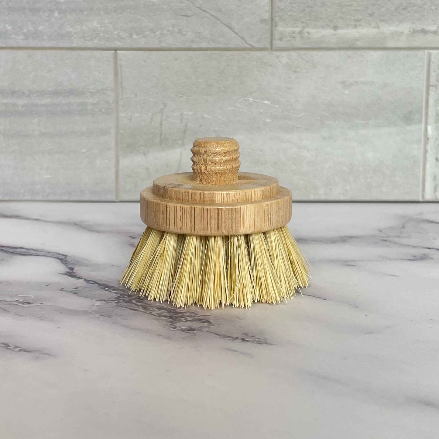 Sisal bristle brush with bamboo handle on a marble surface