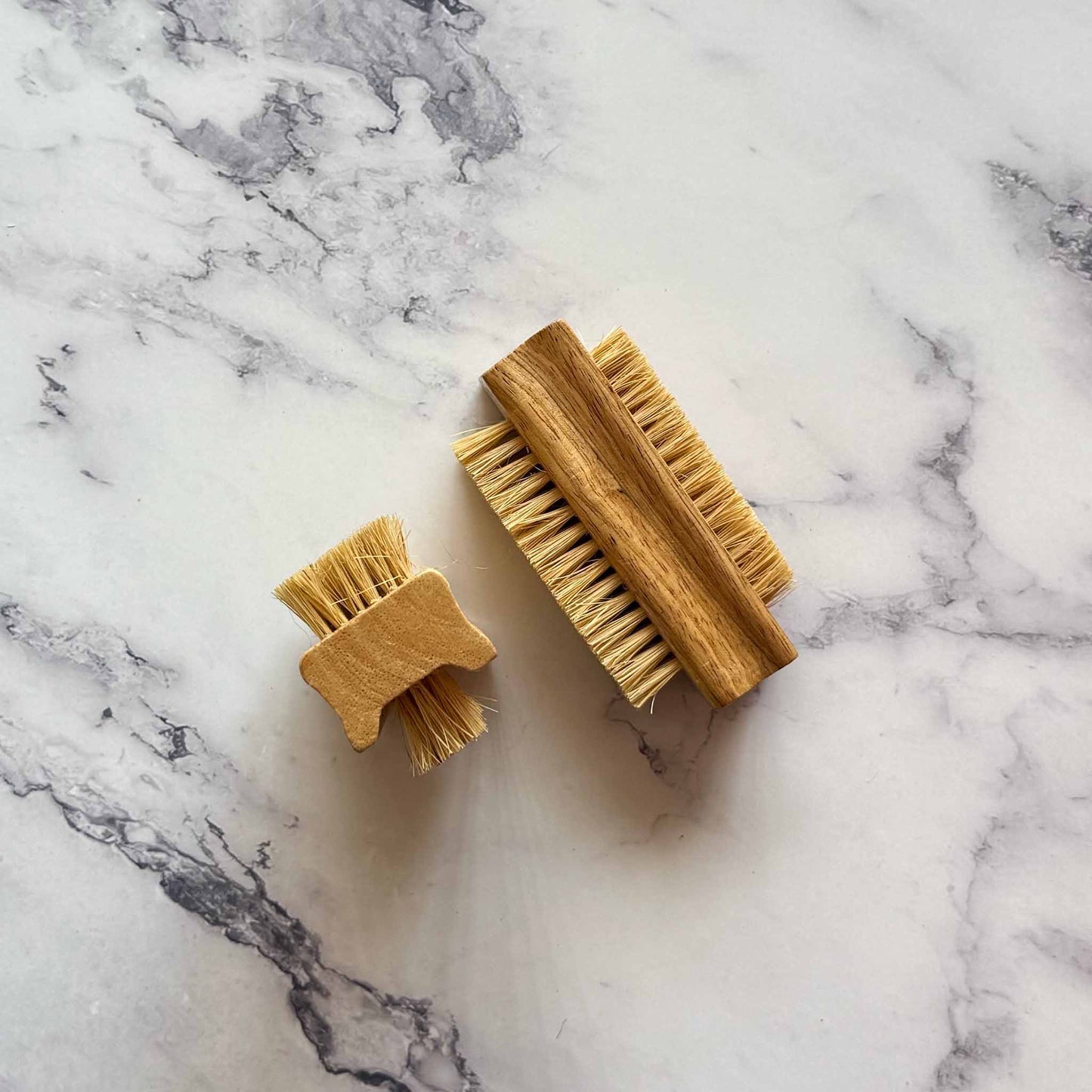 Two wooden brushes on a marble surface