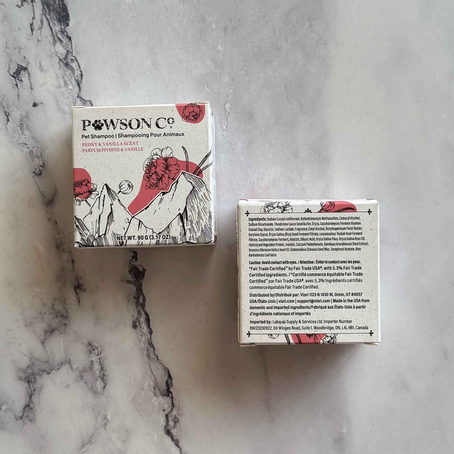 Pet Shampoo Bar boxes, front and back, in Peony and Vanilla scent on a marble surface