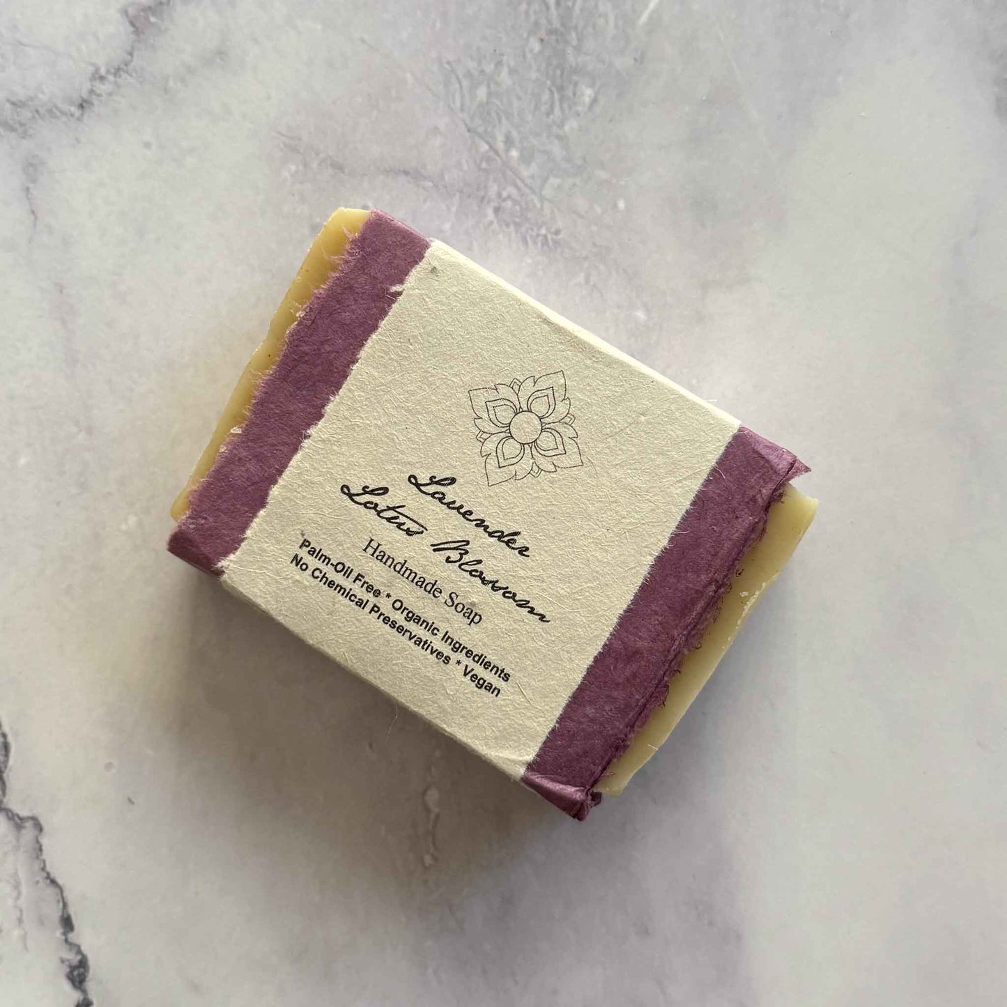 Handmade Lavender Lotus Blossom soap bar with a flower seed paper label on a marble surface