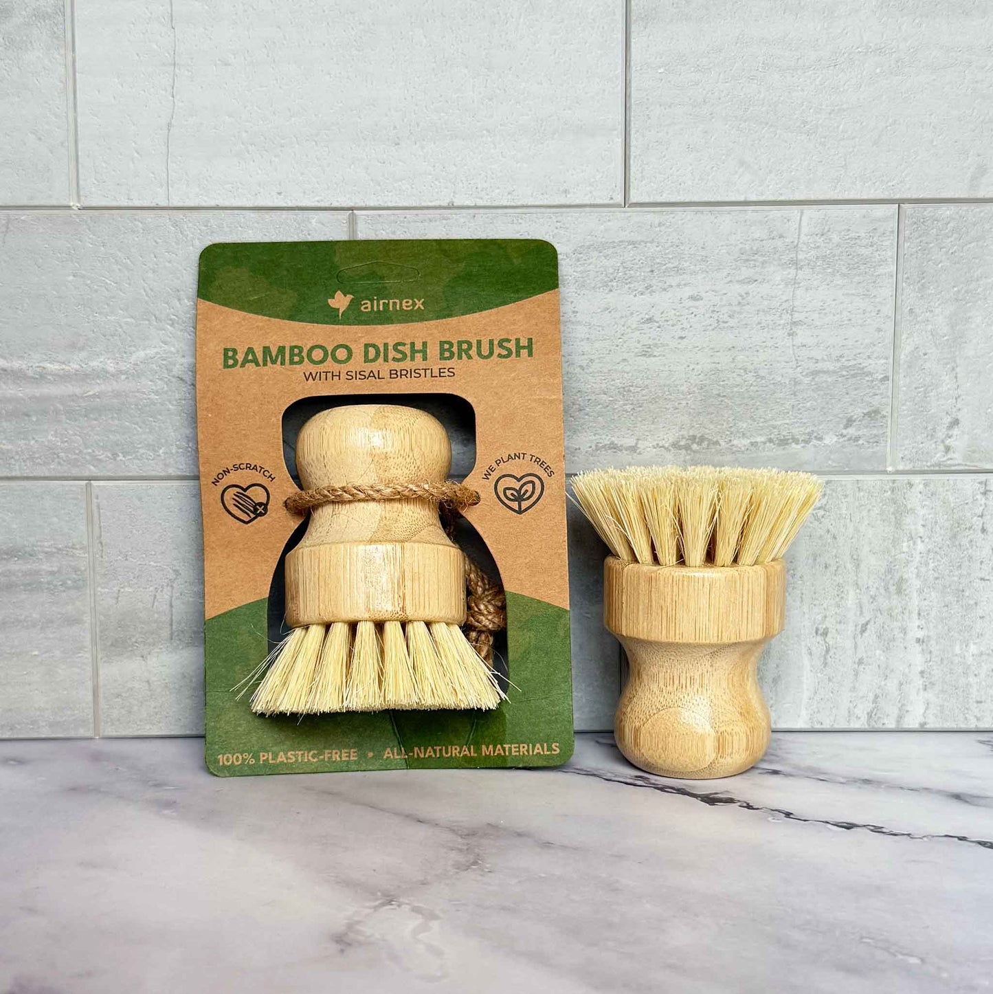 Bamboo dish brush with packaging on a marble surface