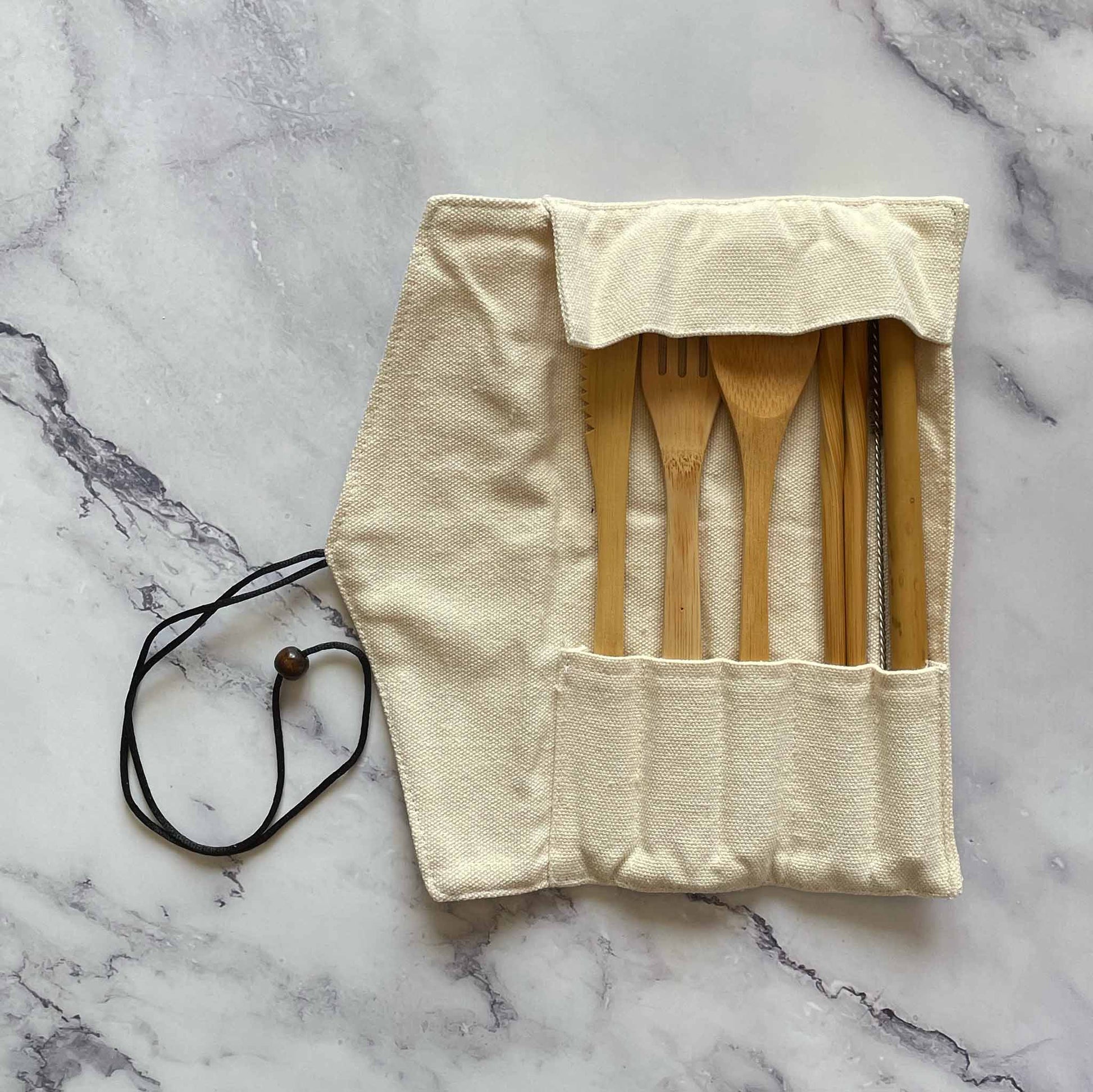 Bamboo Travel Cutlery Set including fork, spoon, knife, straw, straw cleaner, and chopsticks inside the cotton pouch
