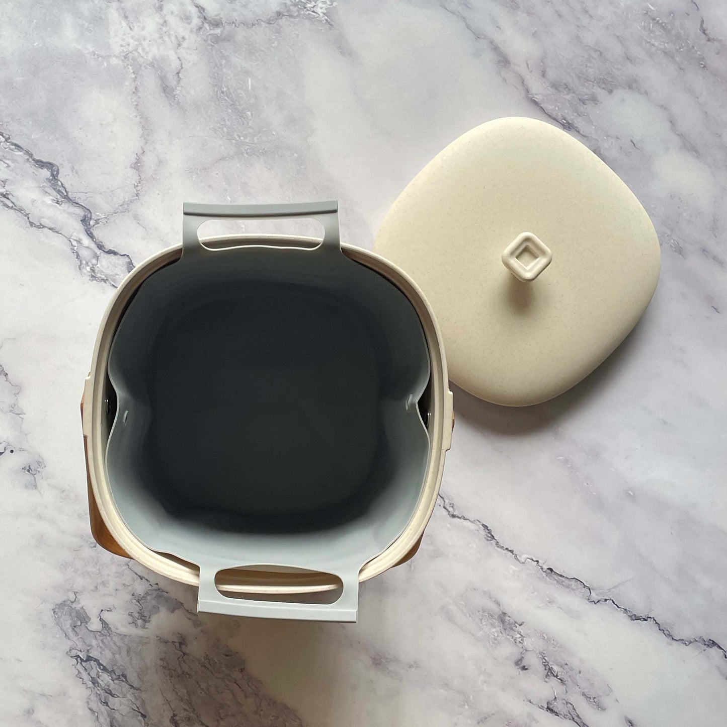 A view from the top of a Bamboozle Compost Bin in Natural  on a marble countertop with a silicone liner in it