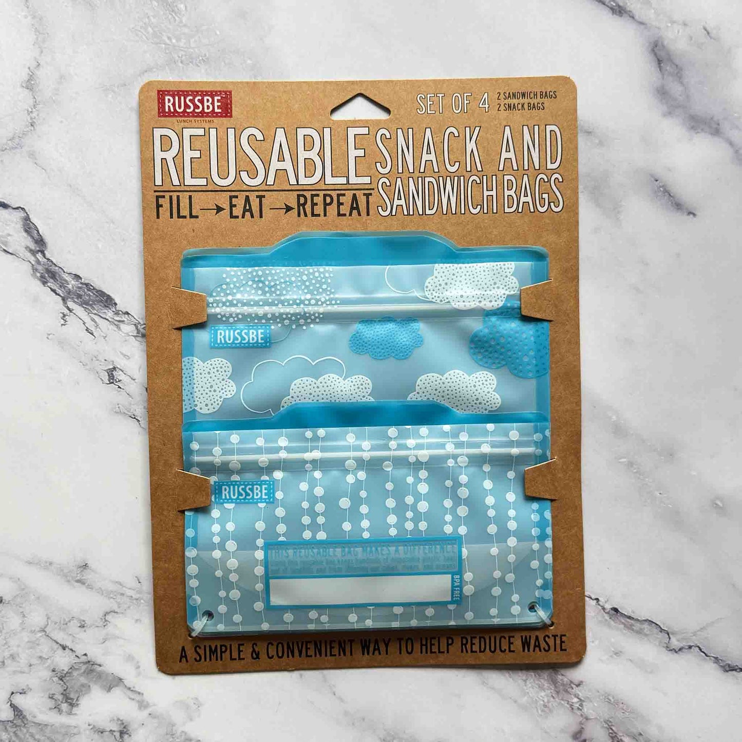 Pack of reusable snack and sandwich bags with blue pattern on a marble background