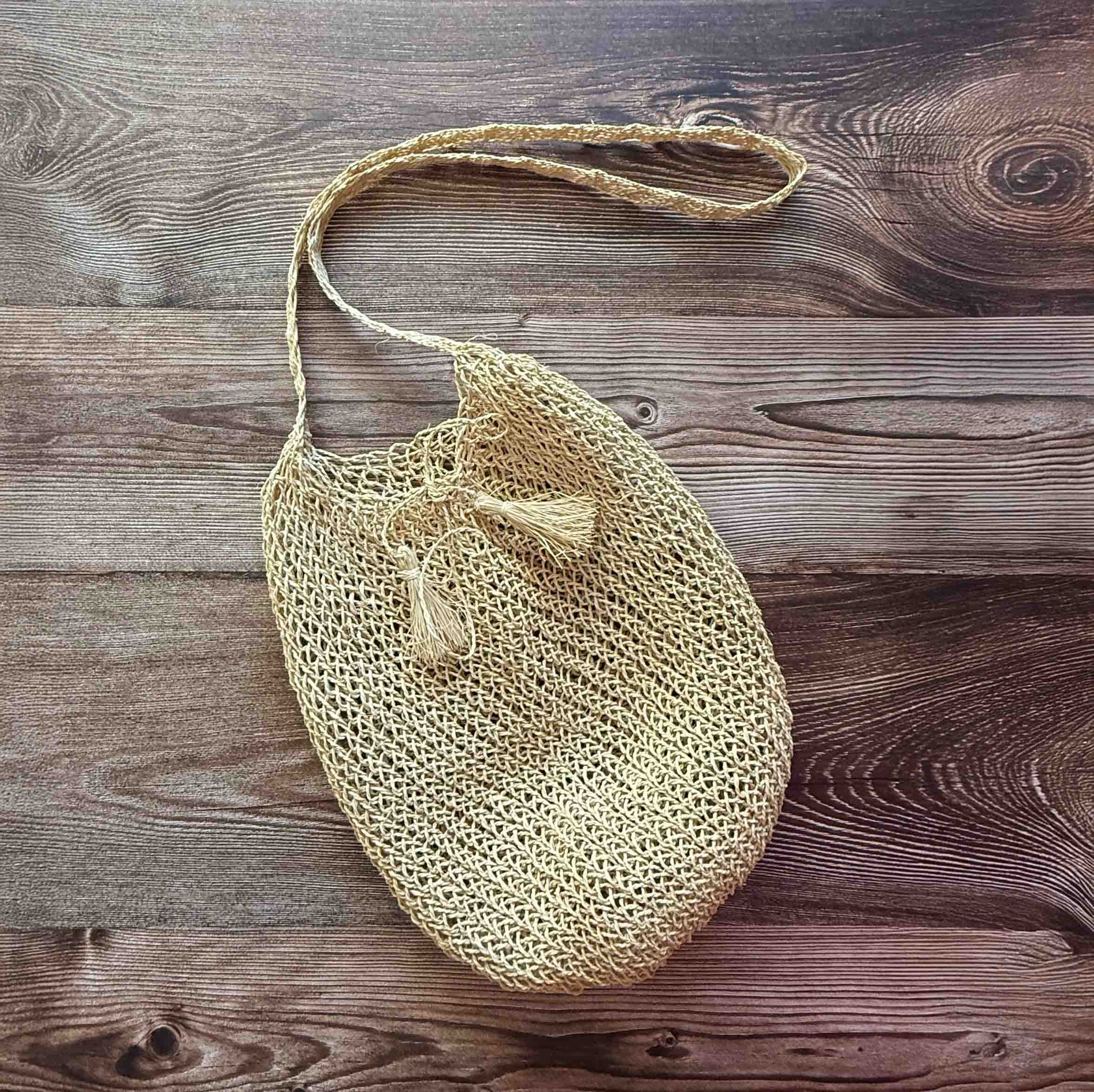 Handwoven Cumare Fiber Mochila  with a strap on a wooden surface