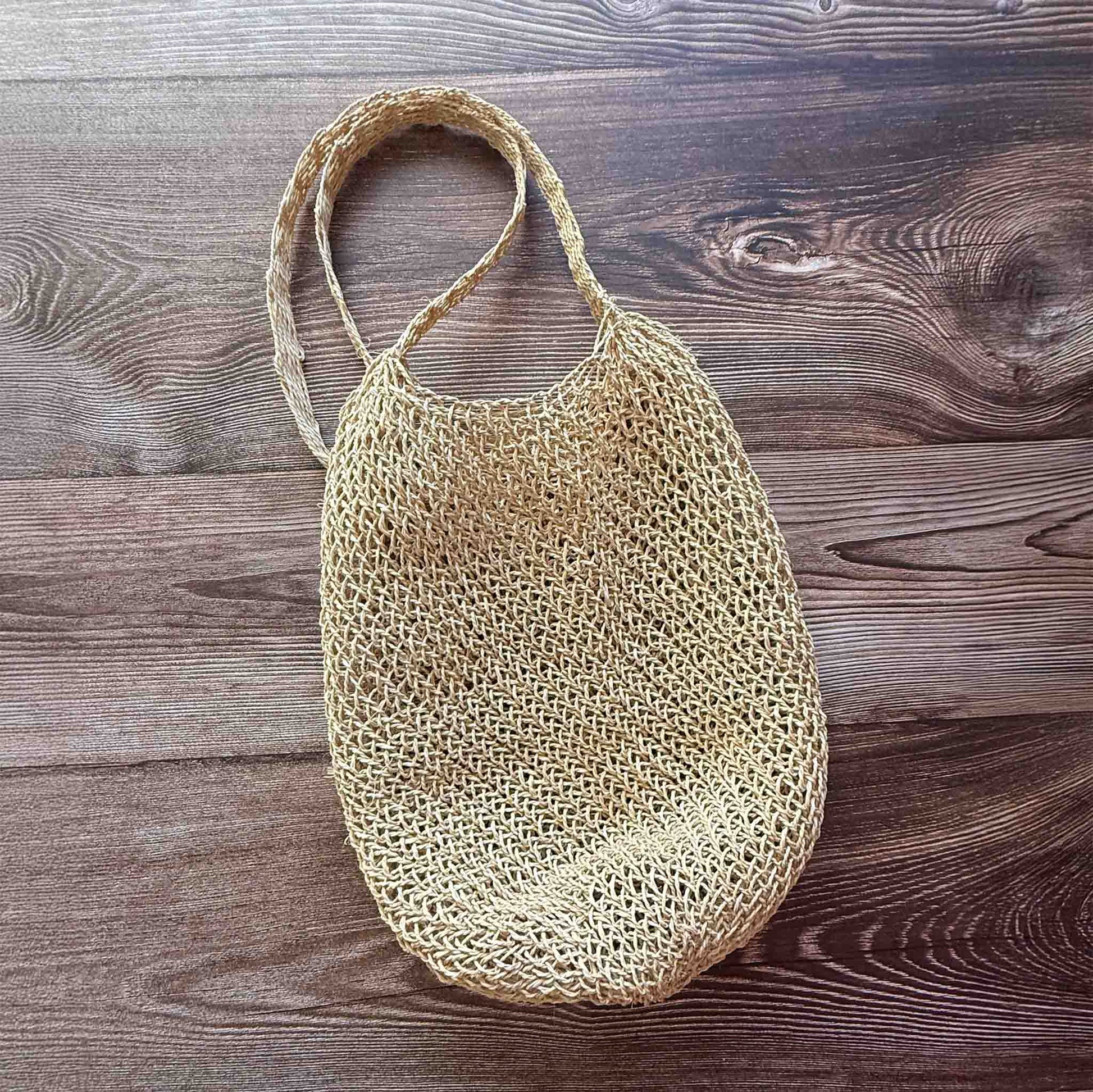 Handwoven Cumare Fiber Mochila  with a strap on a wooden surface