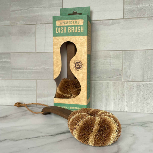 Dish brush with packaging on a marble surface and tiled wall background