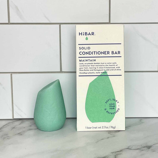 HiBAR Maintain solid conditioner bar and its packaging on a marble surface with tiled wall background