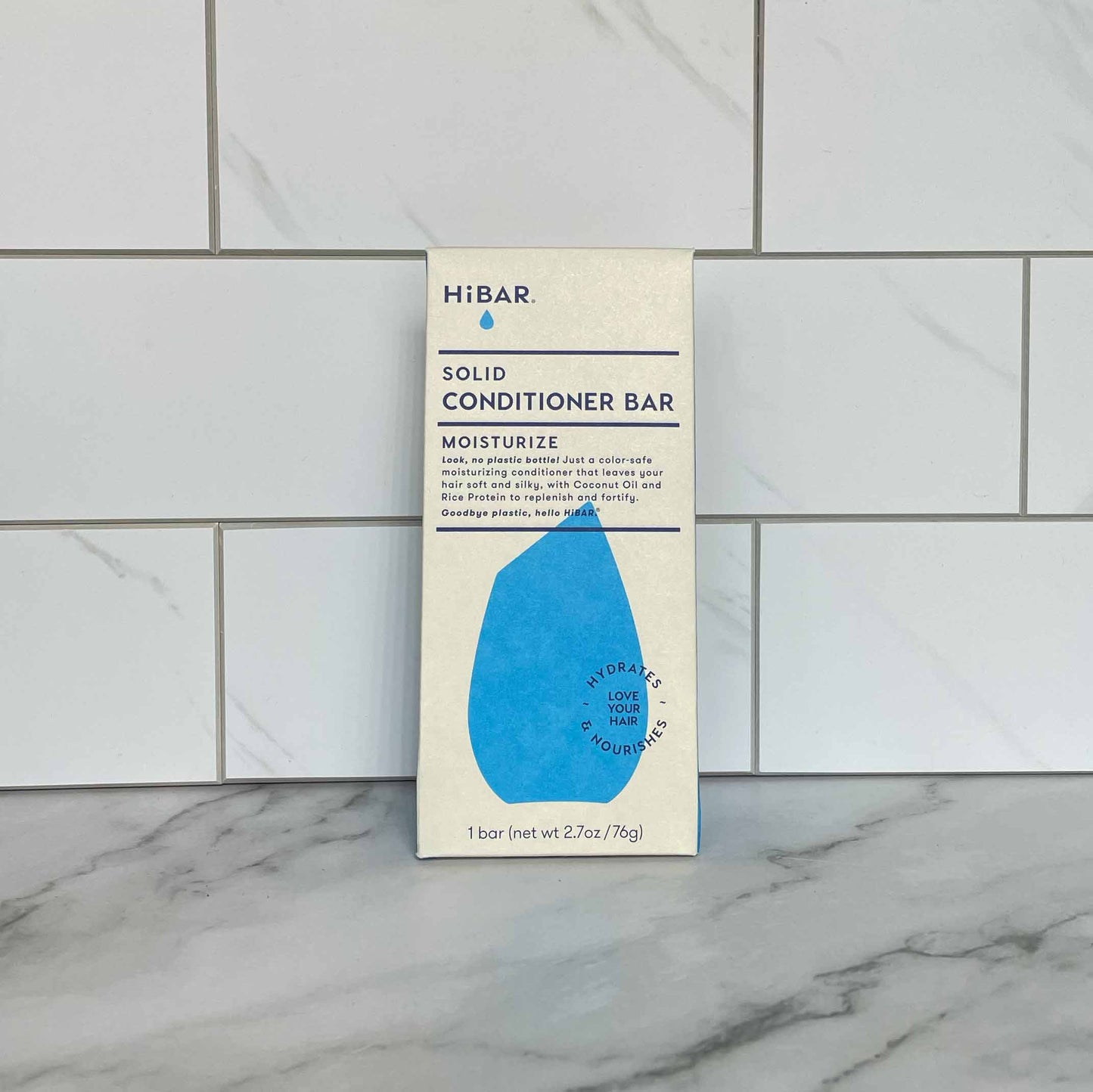 HiBAR Moisturize solid conditioner bar packaging on a marble surface with tiled wall background