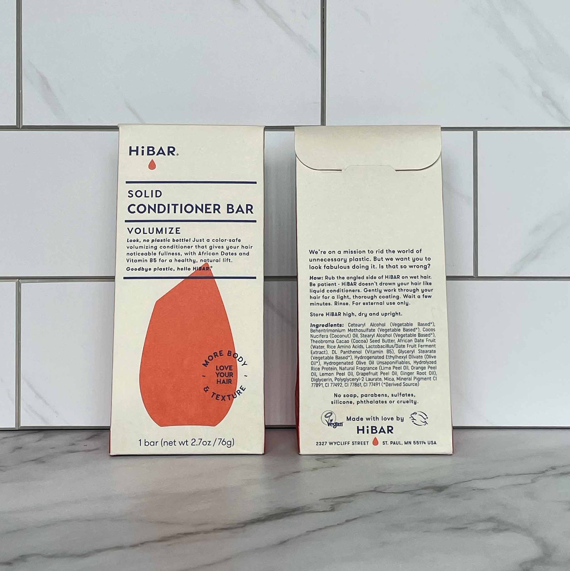 HiBAR Volumize solid conditioner bar packaging on a tiled wall background