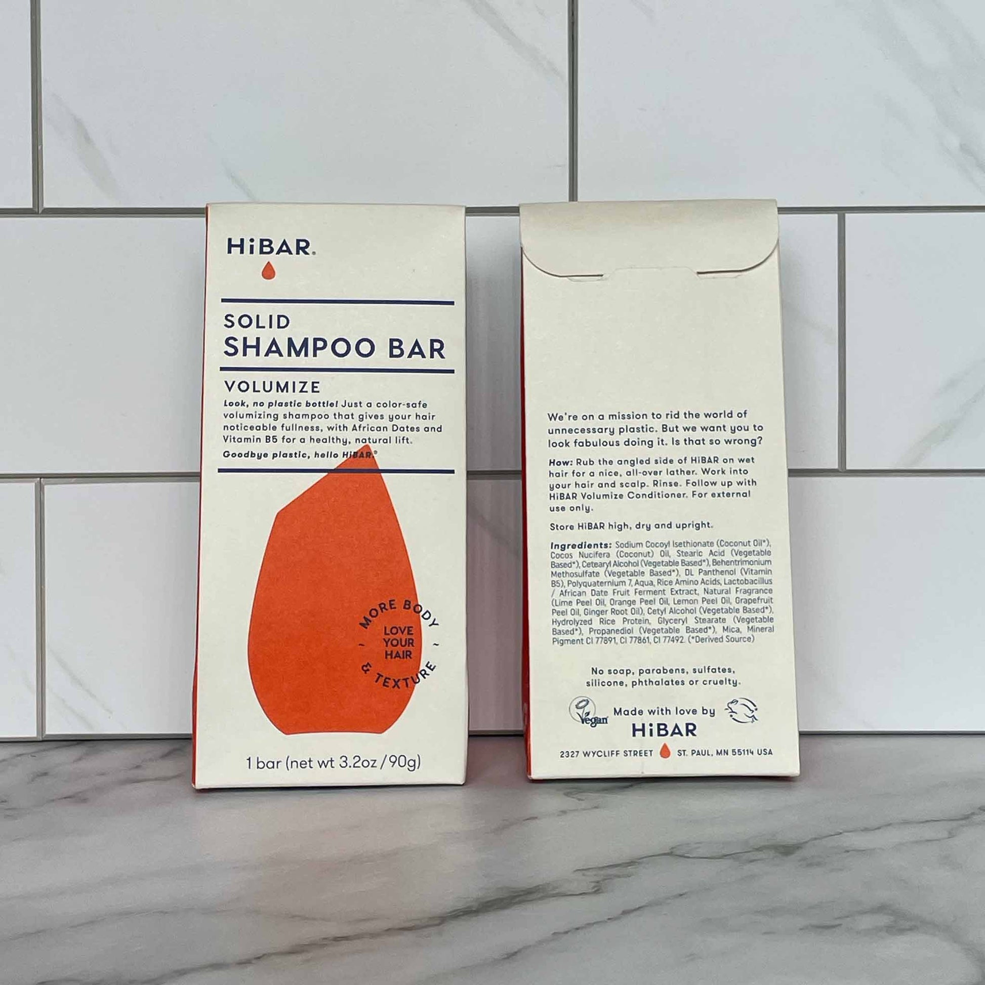 HiBAR Volumize solid shampoo bar packaging on a tiled bathroom floor