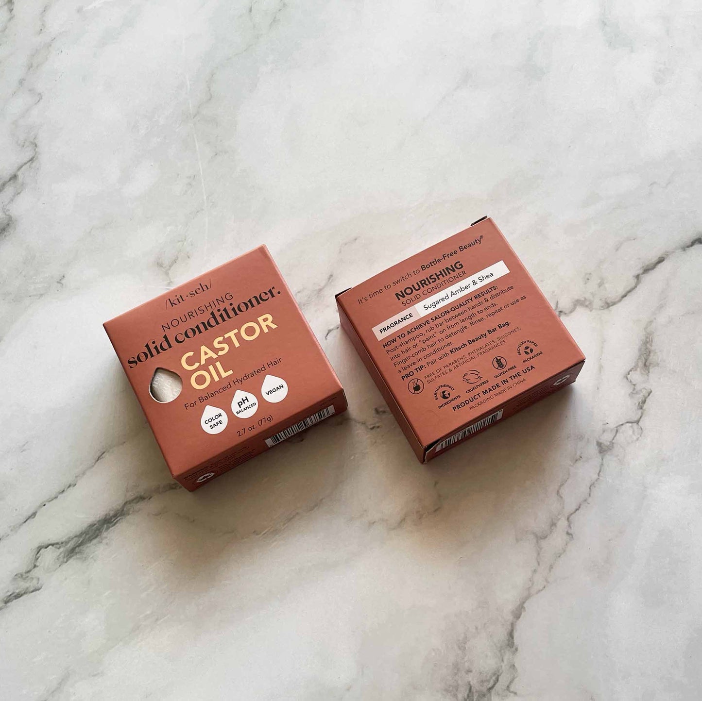 Two boxes of kitsch solid castor oil conditioner on a marble surface
