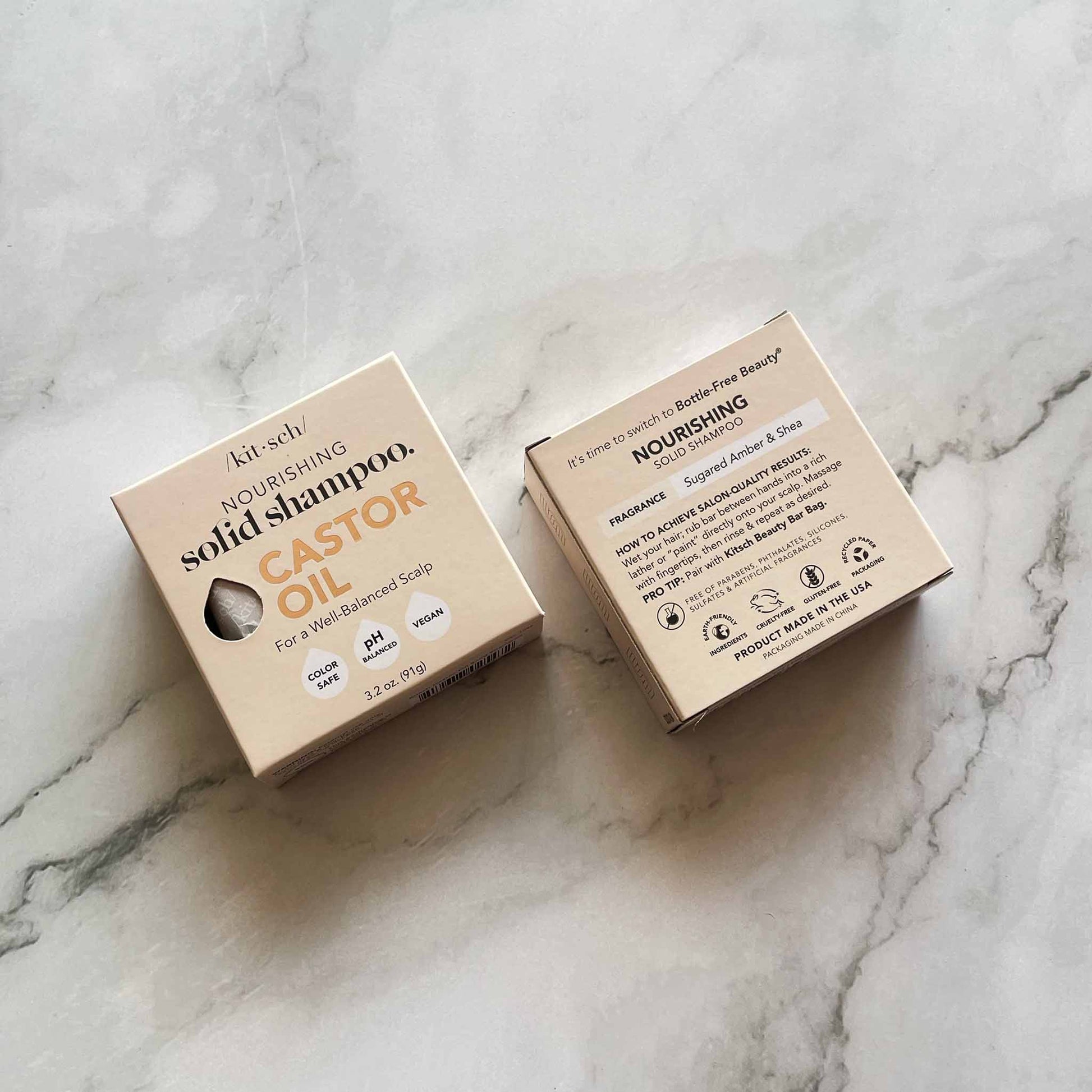 Two cardboard boxes of Kitsch nourishing solid shampoo on a marble surface