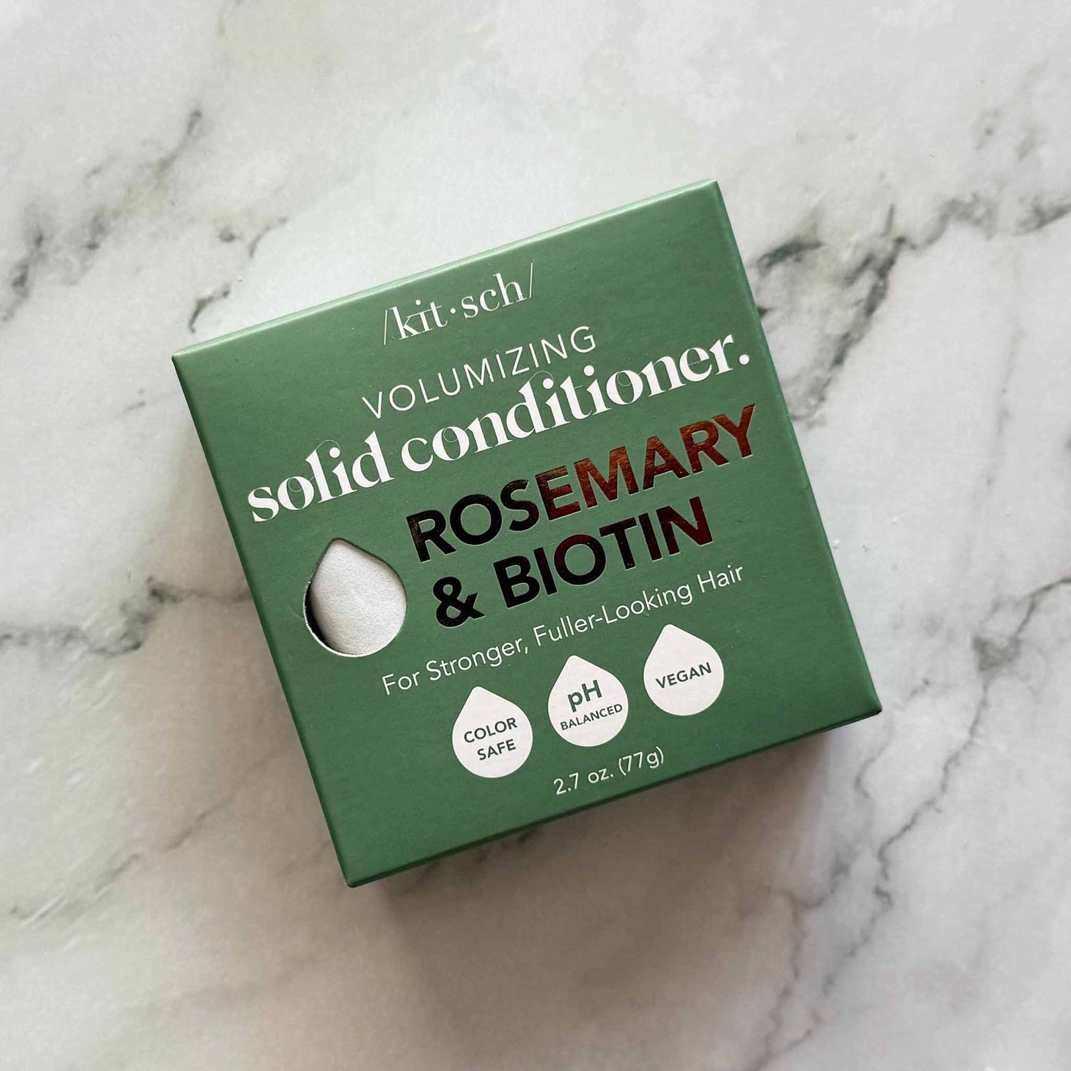 Green box of Kitsch volumizing solid conditioner with rosemary and biotin on a marble background