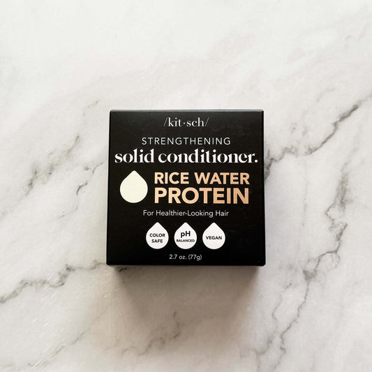 Box of kitsch strengthening solid conditioner with rice water protein on a marble surface