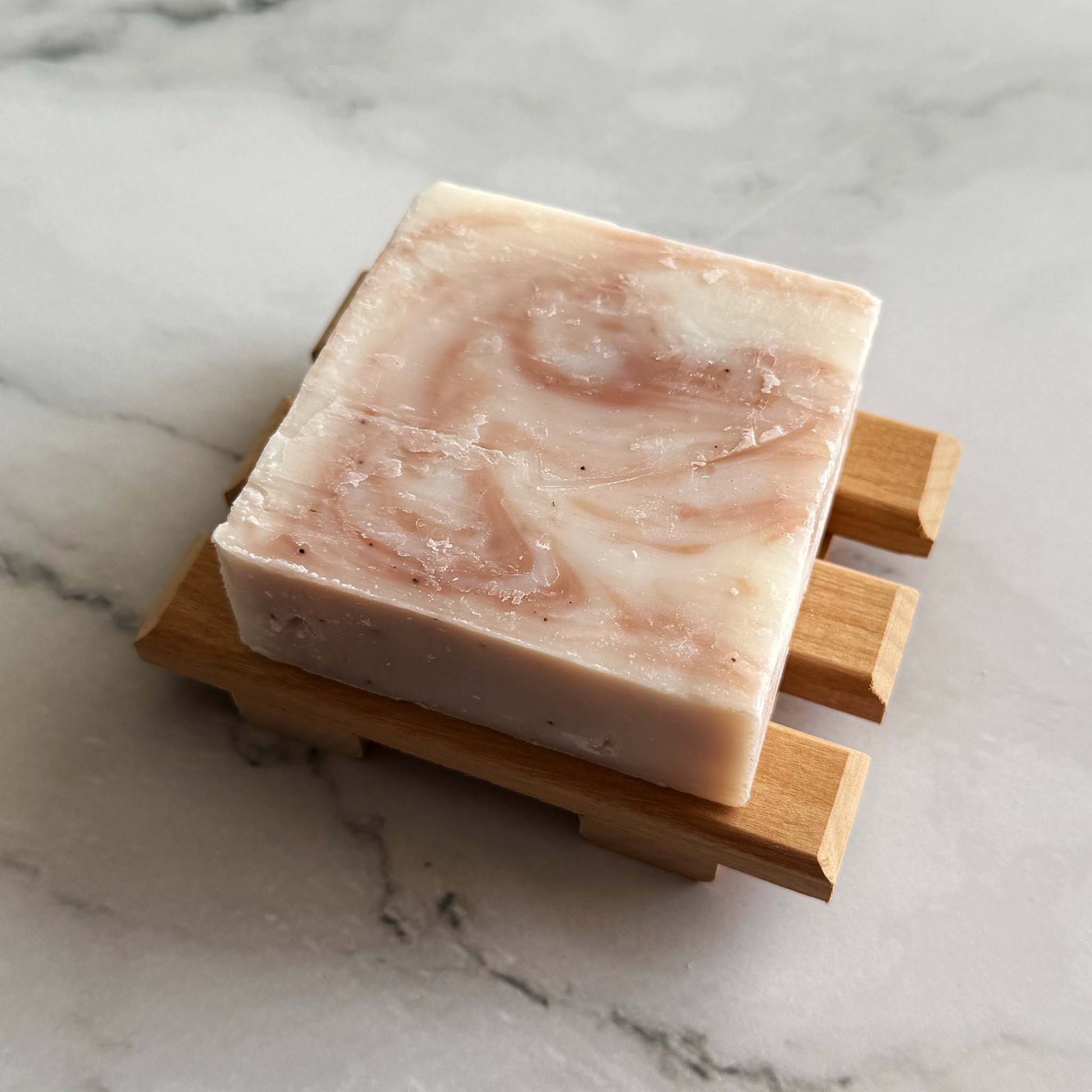 Kitsch shea butter Bar of soap on a wooden soap dish against a marble background