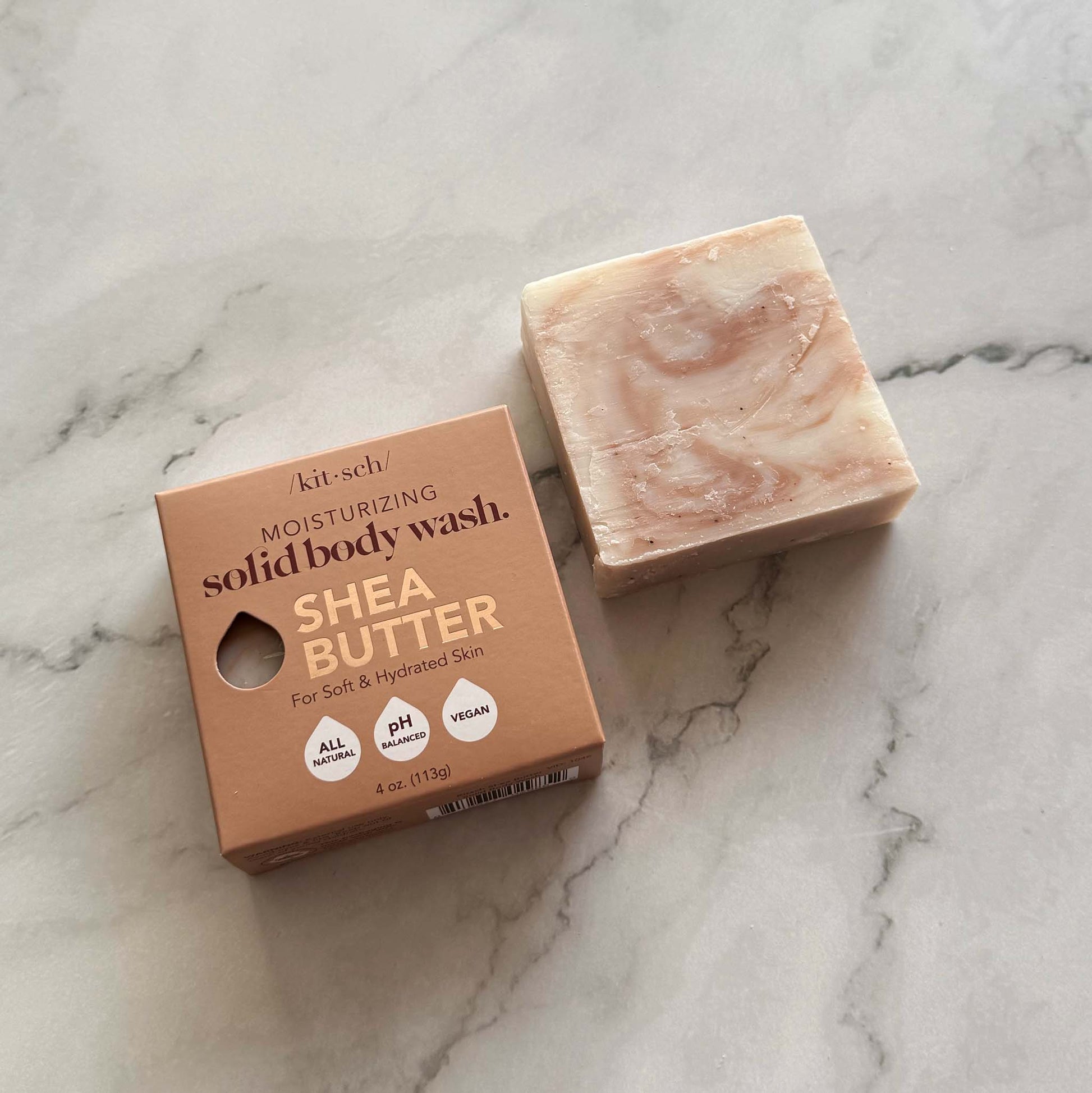 Kitsch Shea butter solid body wash bar and packaging on a marble surface