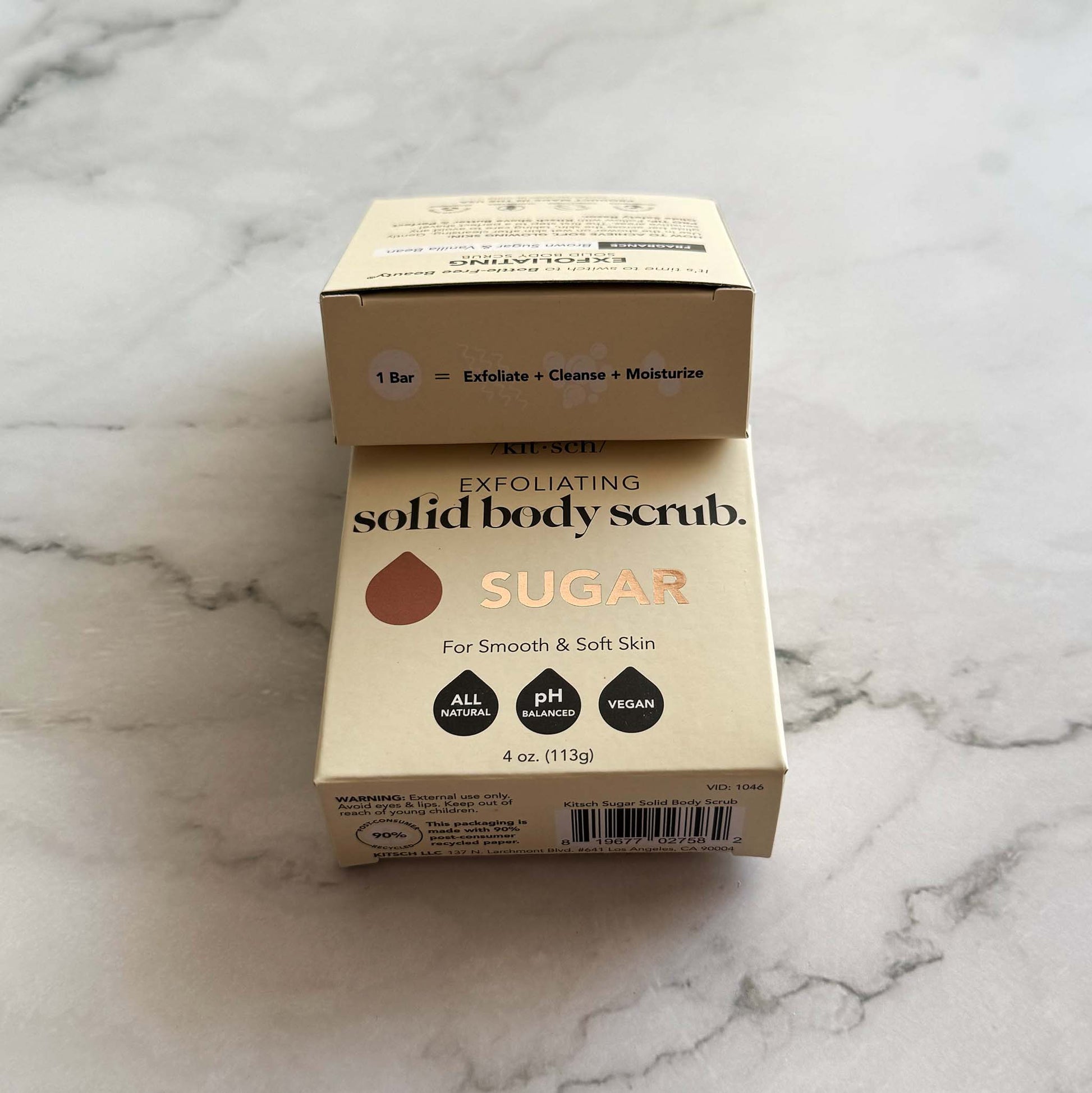 Box of Kitsch exfoliating solid body scrub bar with sugar on a marble surface