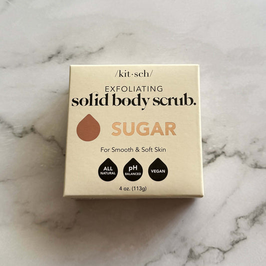 Box of Kitsch exfoliating sugar solid body scrub bar on a marble surface