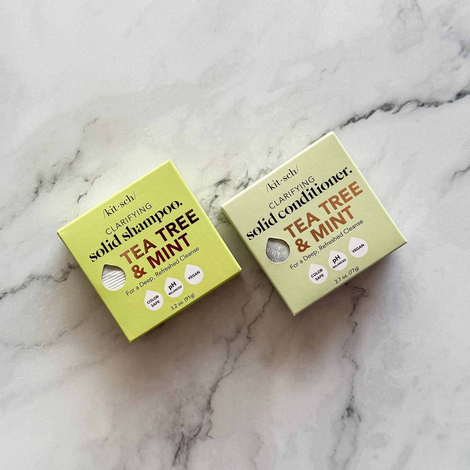 Two boxes of Kitsch solid shampoo and conditioner on a marble surface