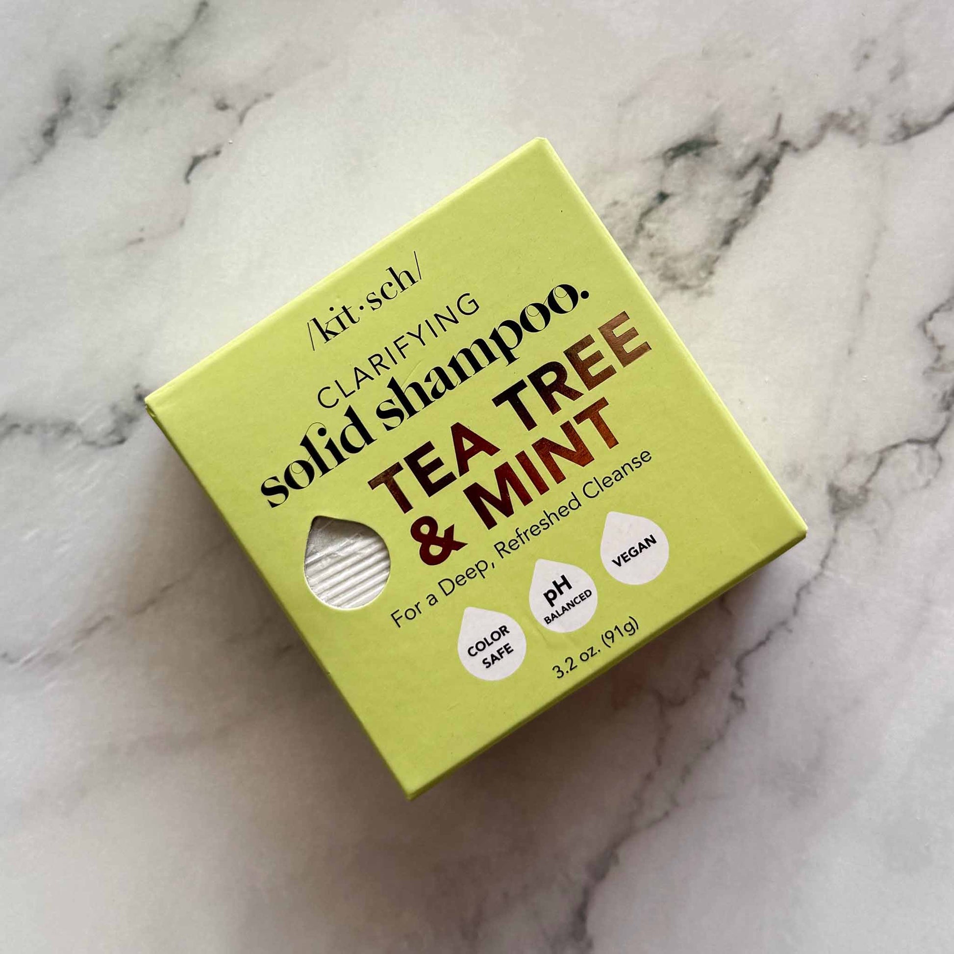 Box of Kitsch clarifying solid shampoo with tea tree and mint on a marble background