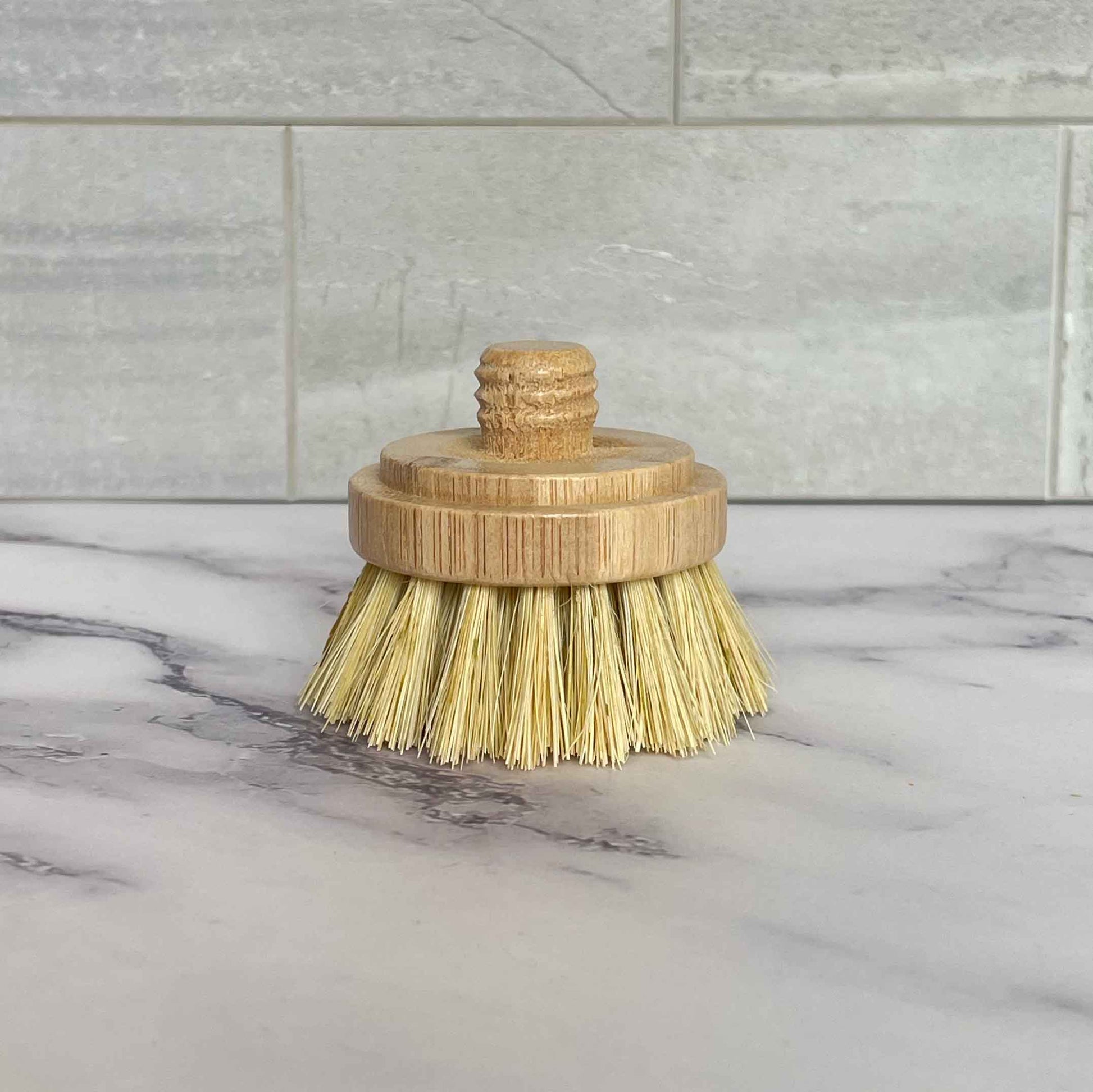 Sisal bristle brush with bamboo handle on a marble surface