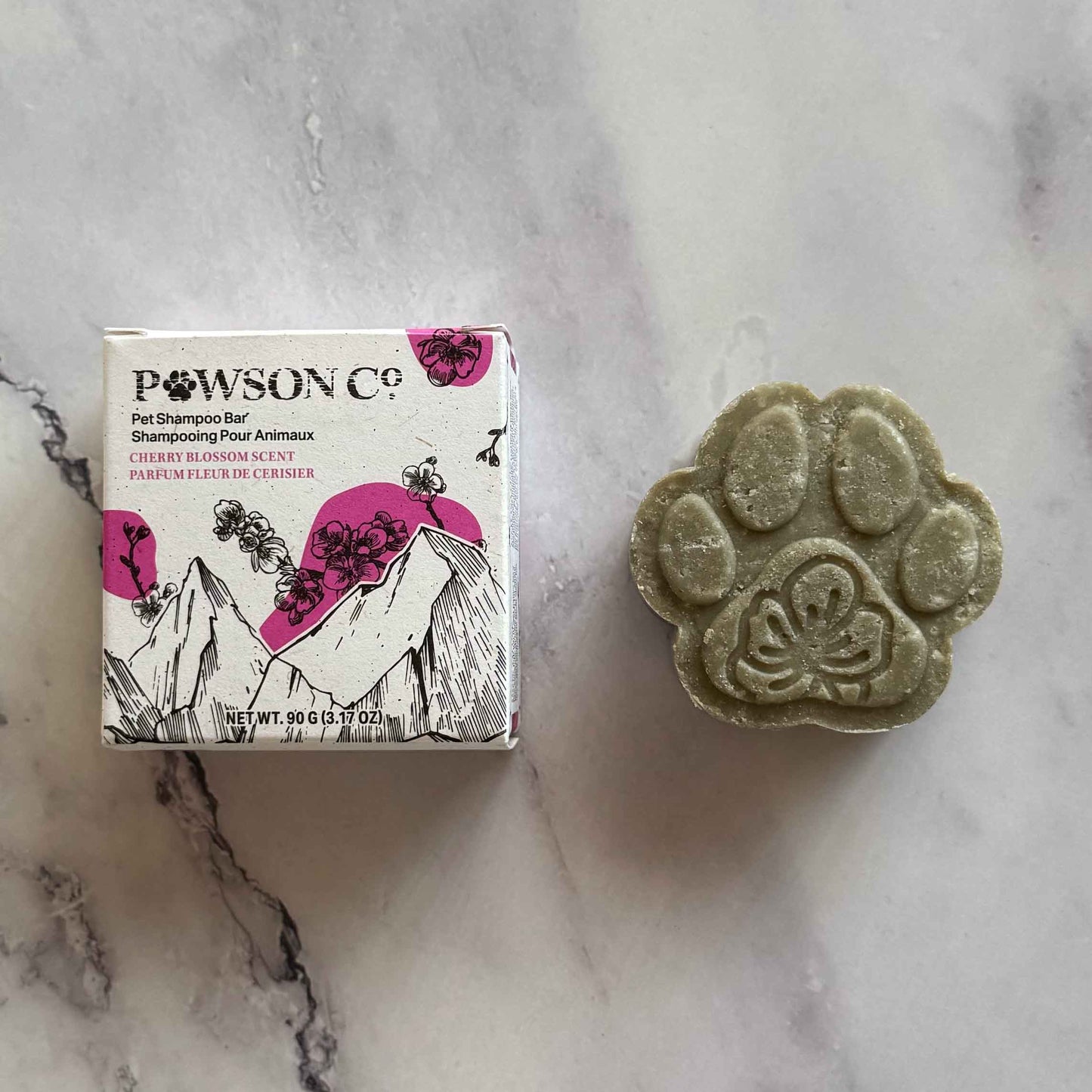 Pet Shampoo Bar in Cherry Blossom scent on a marble surface next to its box
