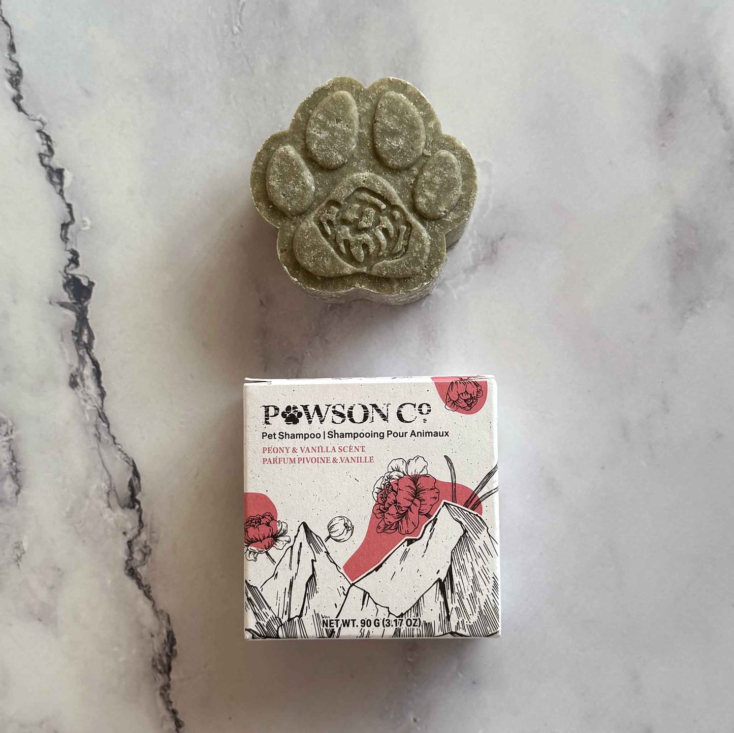 Pet Shampoo Bar in Peony and Vanilla scent on a marble surface next to its box