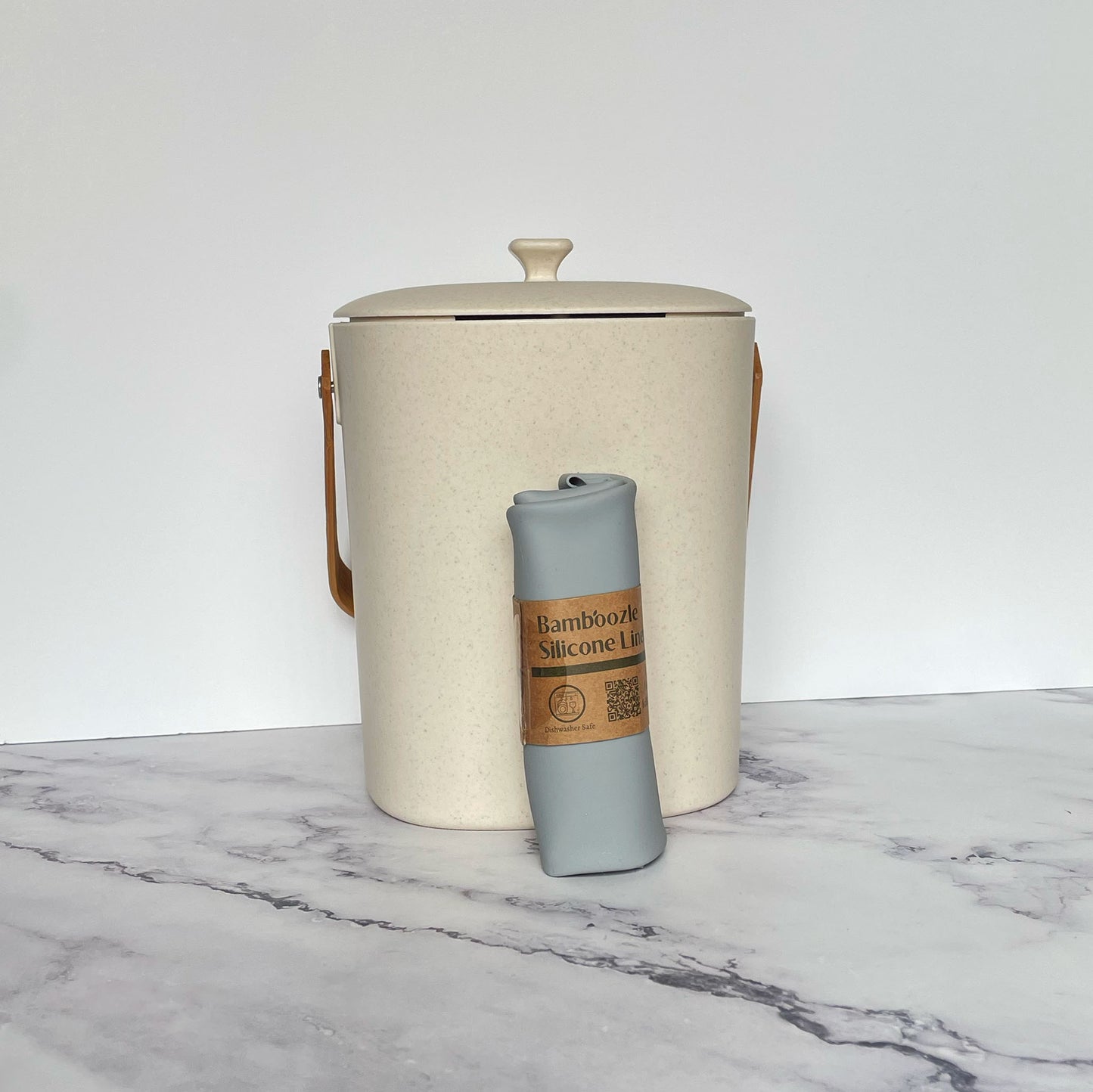 Silicone Compost Bin Liner against a Natural compost bin on a marble surface