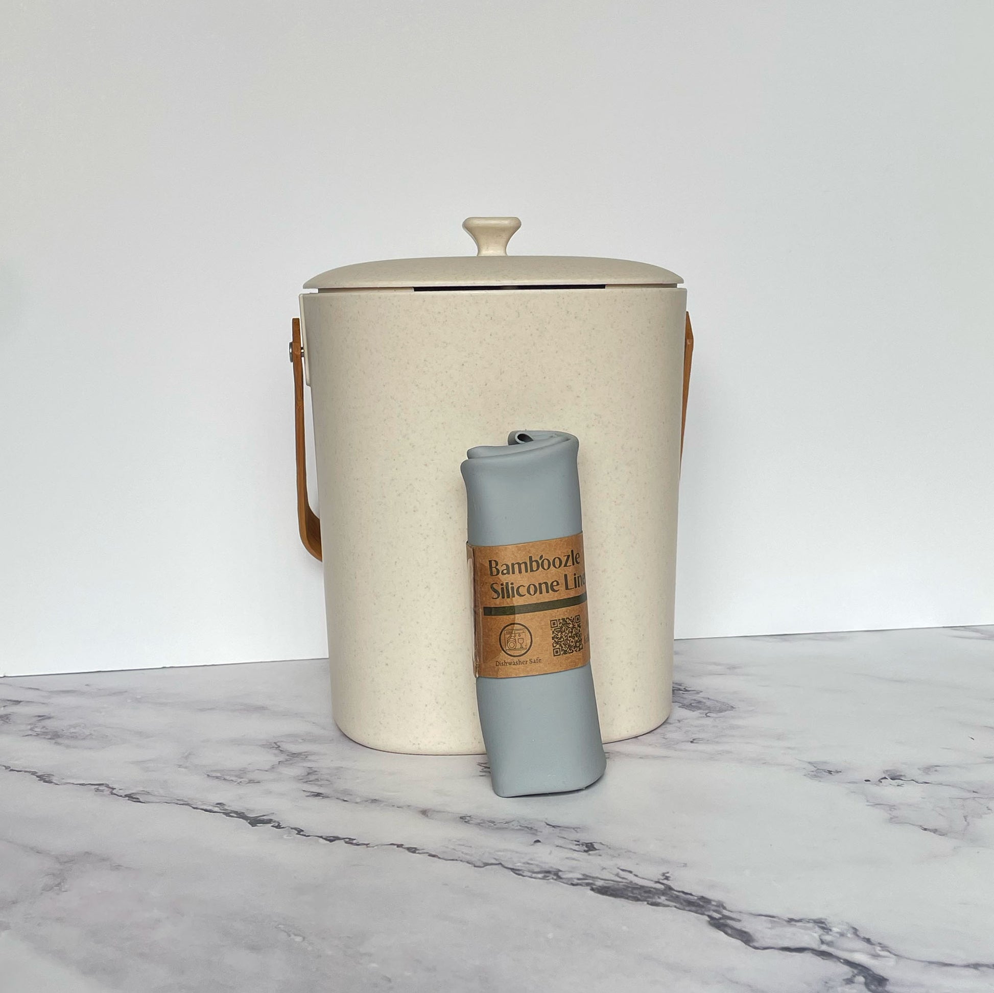 Silicone Compost Bin Liner against a Natural compost bin on a marble surface