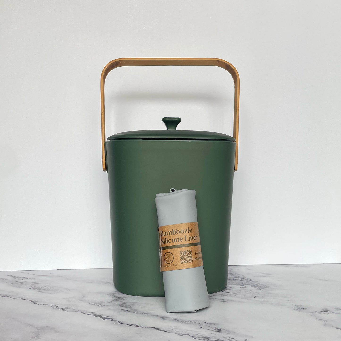 Silicone Compost Bin Liner against a forest compost bin on a marble surface