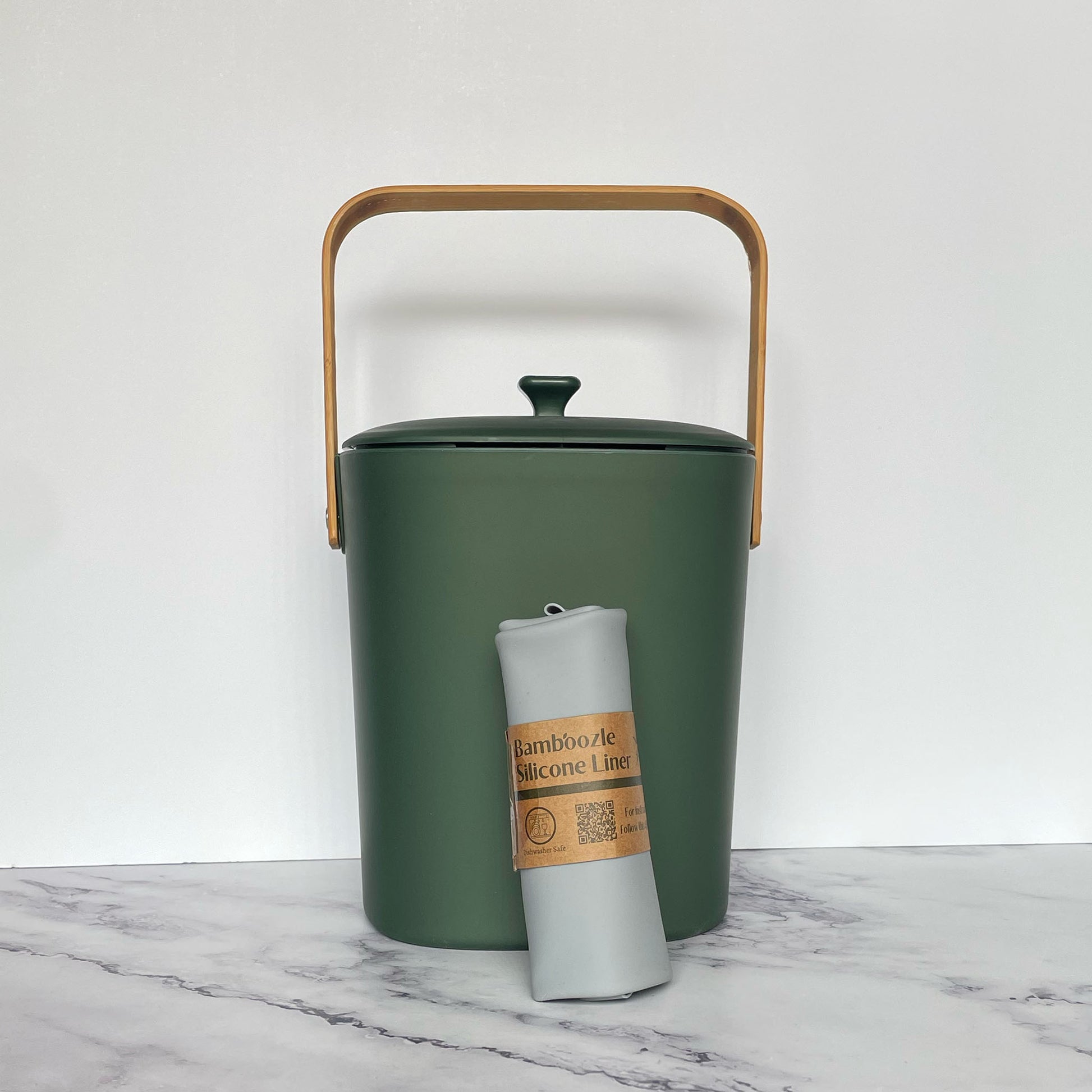 Silicone Compost Bin Liner against a forest compost bin on a marble surface