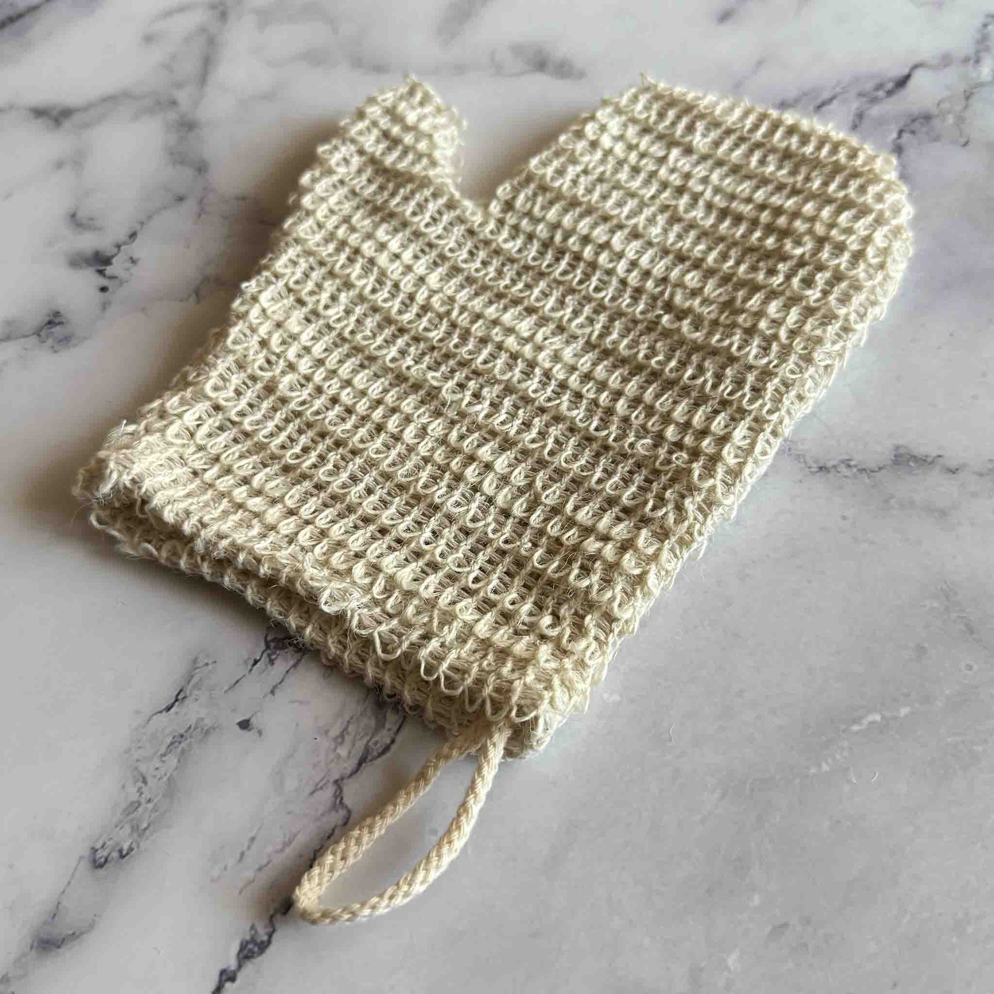Sisal Exfoliating Shower Glove on marble surface