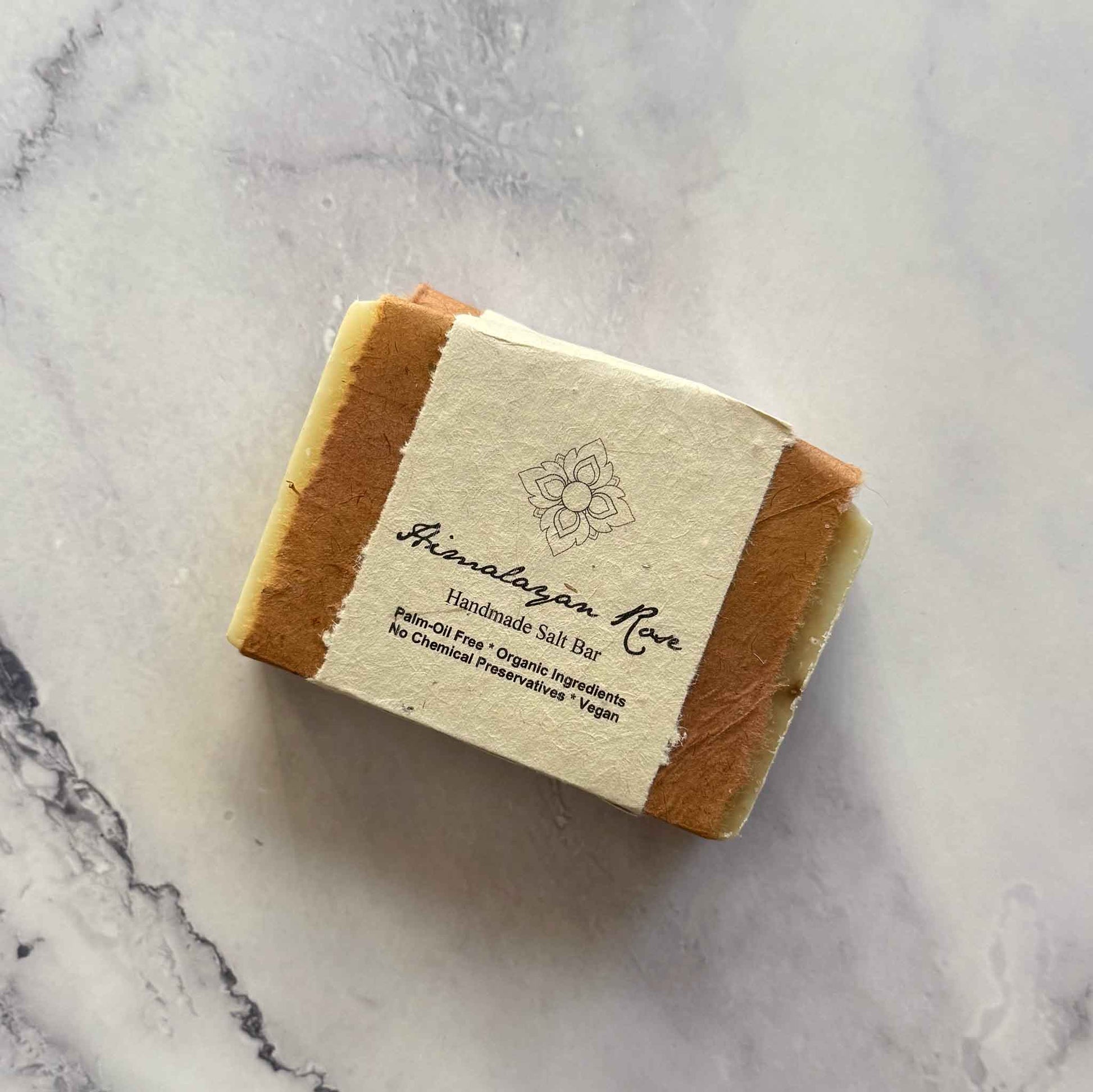 Handmade Himalayan Rose soap bar with a flower seed paper label on a marble surface