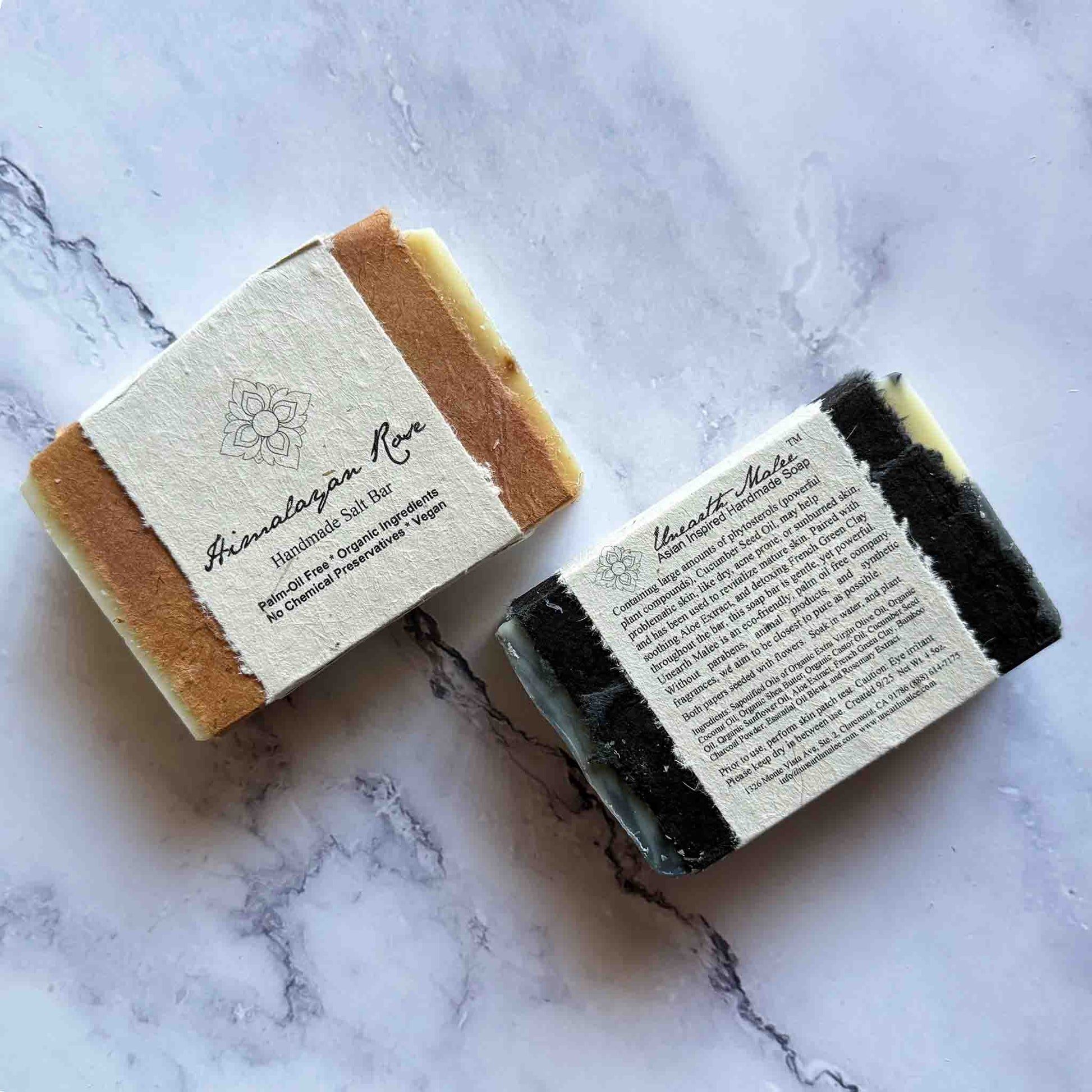 Handmade soap bars with flower seed paper labels on a marble surface