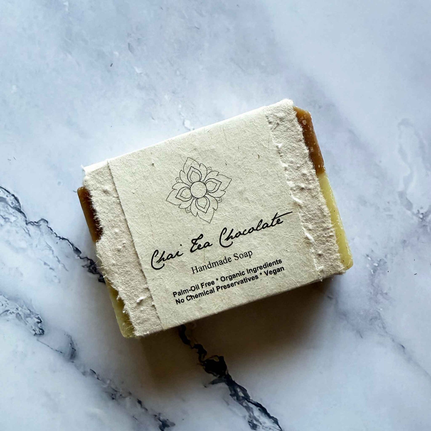 Handmade Chai Tea Chocolate soap bar with a flower seed paper label on a marble surface